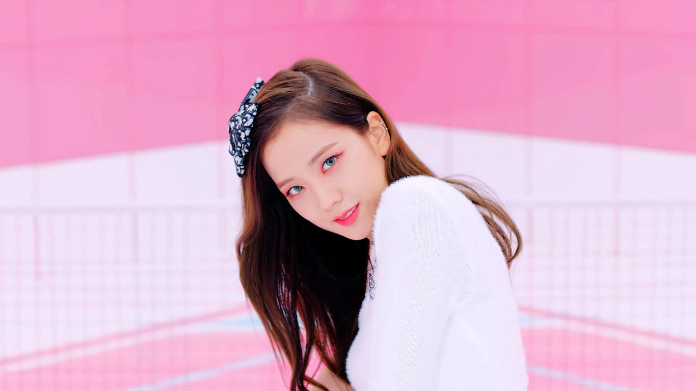 可愛的Jisoo BLACKPINK 壁紙 — 一位長髮棕眼、戴著花卉頭帶的年輕女性，穿著白色毛衣，在充滿活力的粉紅色瓷磚牆前溫柔微笑。