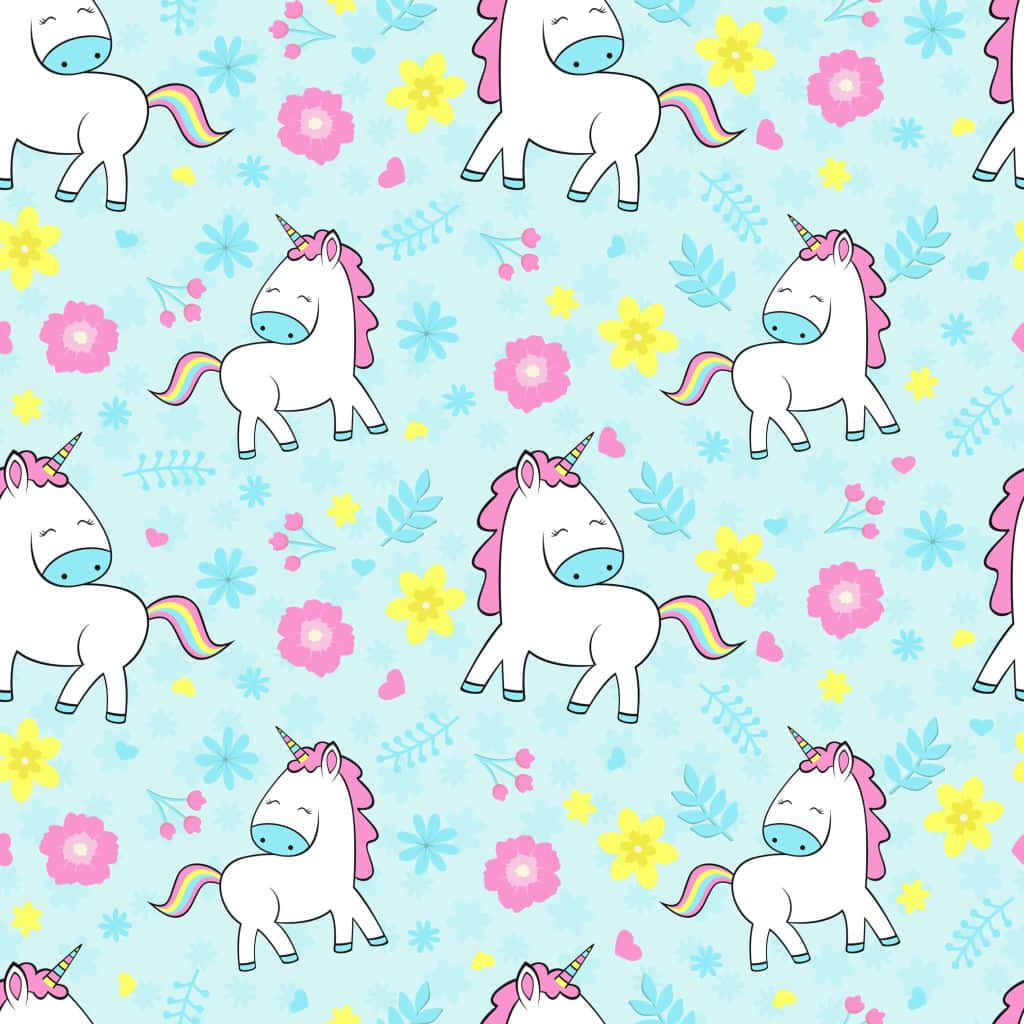 Pastel Unicorn 桌布 壁紙 — 可愛的卡通獨角獸，擁有彩虹尾巴和粉紅色鬃毛，在淺藍色背景上的柔和花朵間漫步。