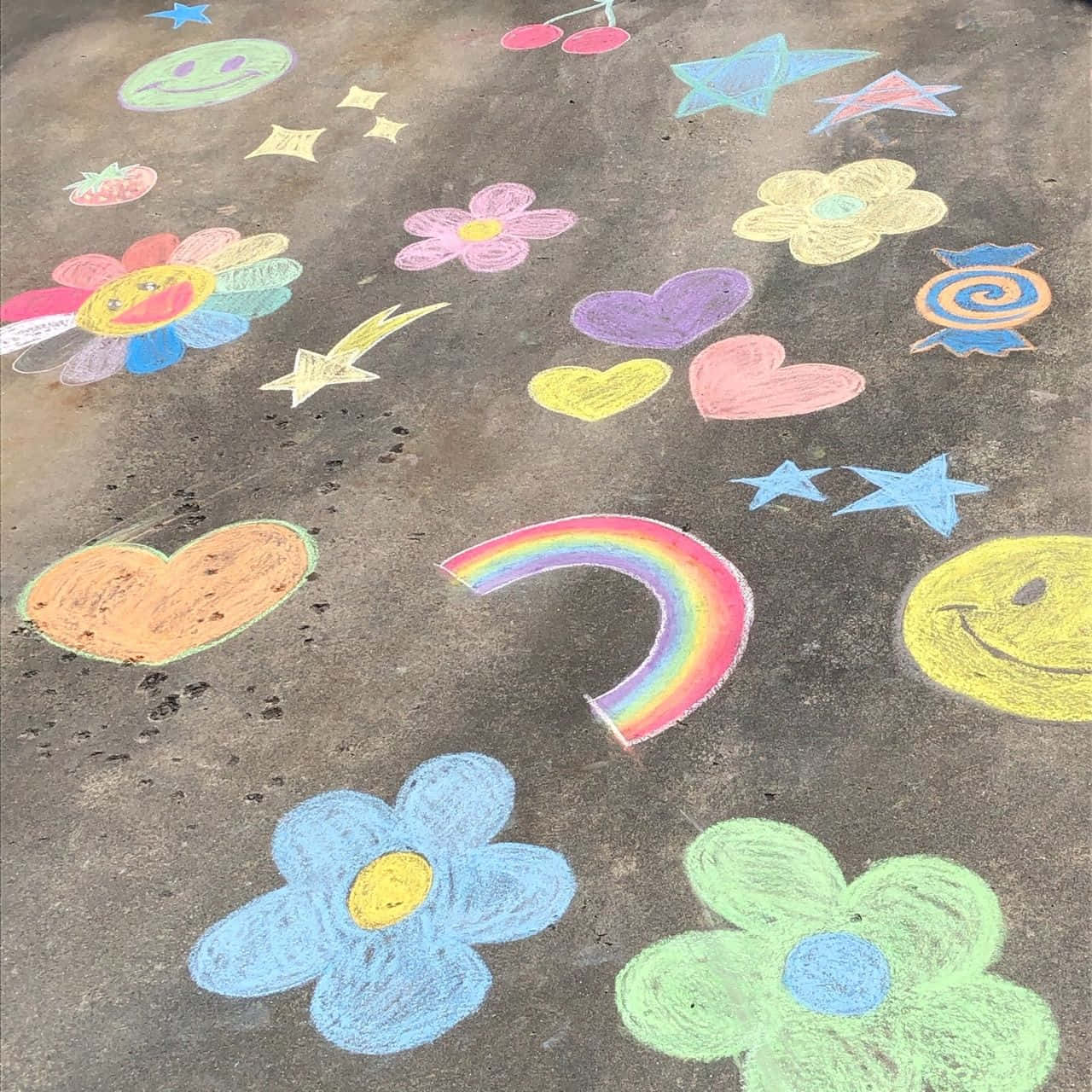 行人路上明亮的粉筆藝術，包含花朵、心形、星星和彩虹。