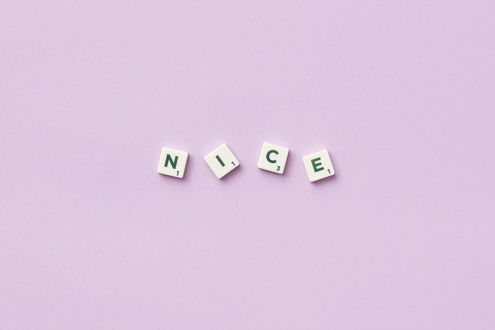 四個 Scrabble 字塊在紫色背景上拼出 nice