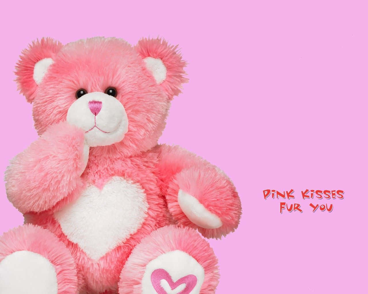 帶有白色心形補丁和 pink kisses for you 文字的粉紅色泰迪熊。