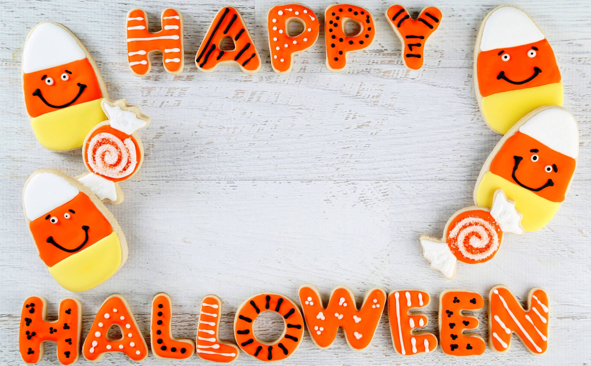Happy Halloween 餅乾，形狀像糖果玉米和棒棒糖，放在白色木質背景上。