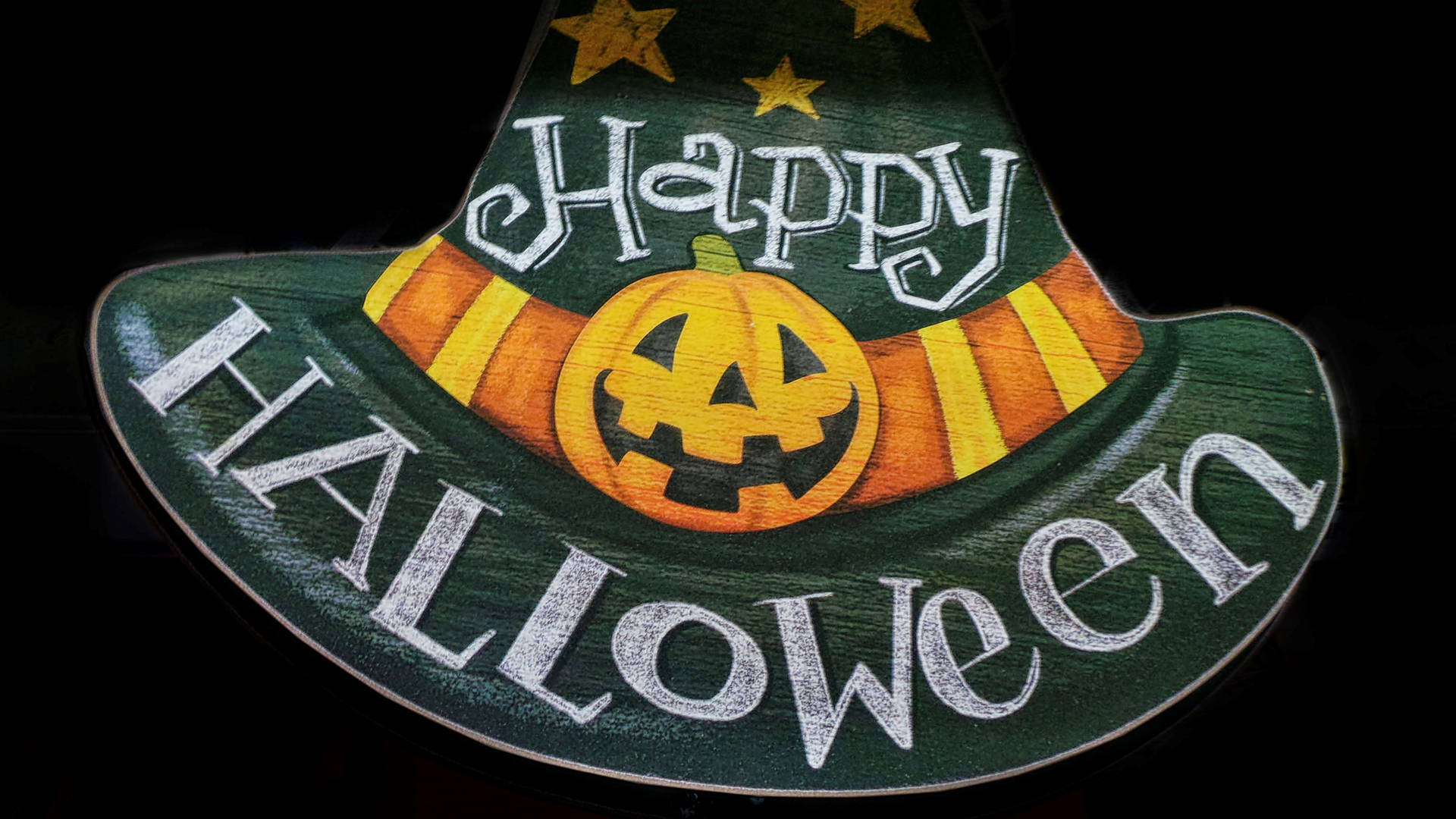 一個木製女巫帽裝飾，帶有 'Happy Halloween' 和南瓜燈臉孔。