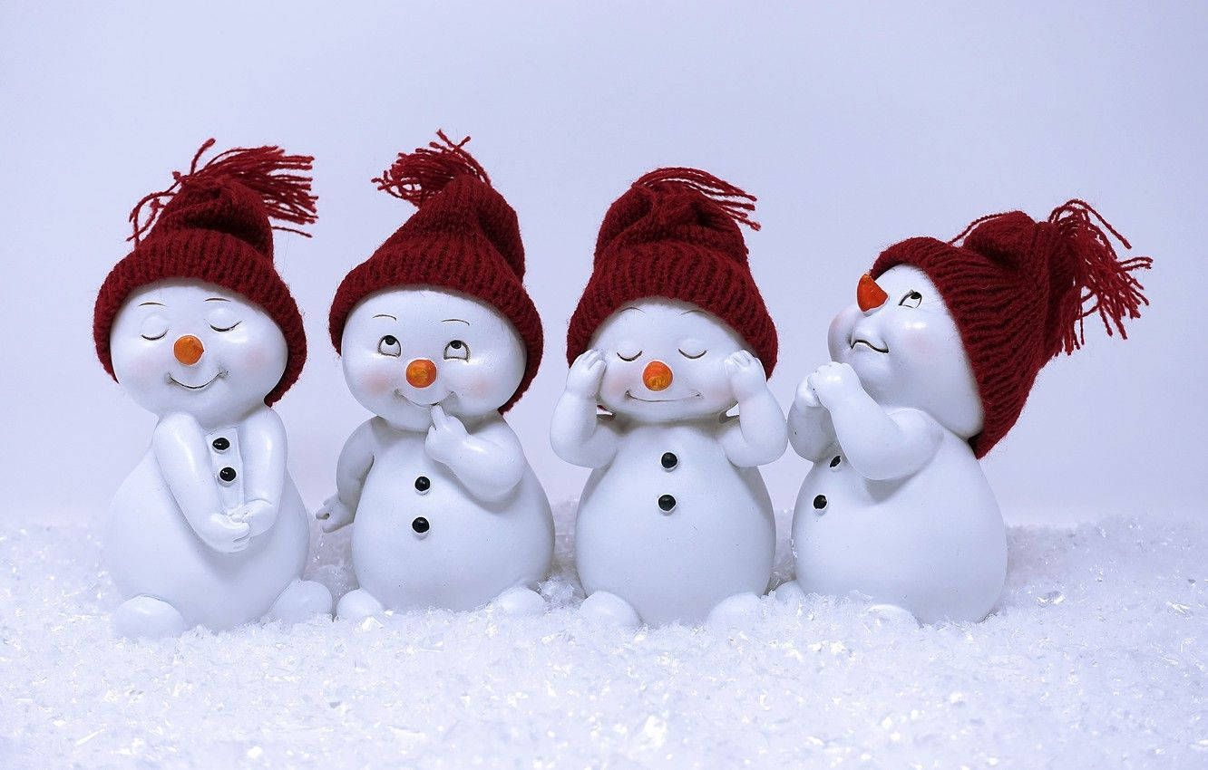 四個戴紅帽的雪人公仔坐在雪中