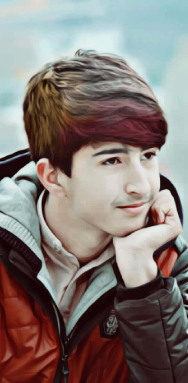 可愛韓國男孩穿紅外套托腮寫真 壁紙 — 一位年輕男子擁有色彩繽紛的頭髮，穿著紅灰色外套，在模糊的城市背景下將下巴靠在手上。