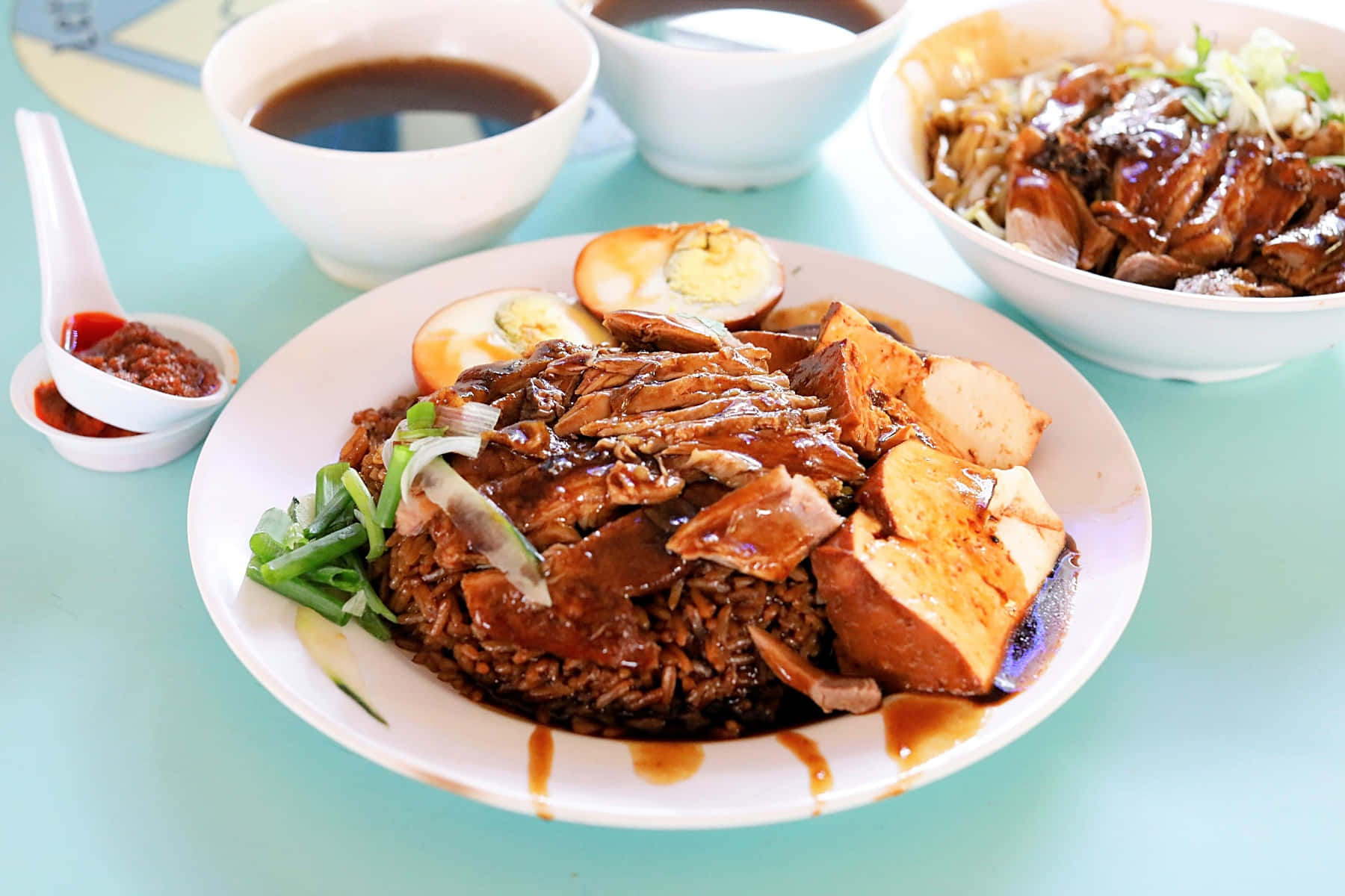 可愛鴨肉飯，醬汁豐盛配豆腐 壁紙 — 淺藍色桌子上的一盤豐富釉面雞肉飯配水煮蛋豆腐和青蔥的特寫。