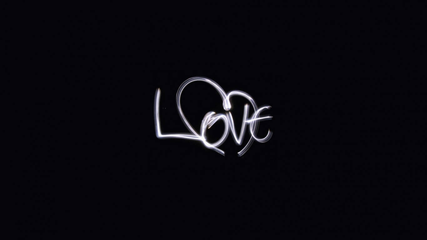 黑色背景上發光的白色手寫love字樣