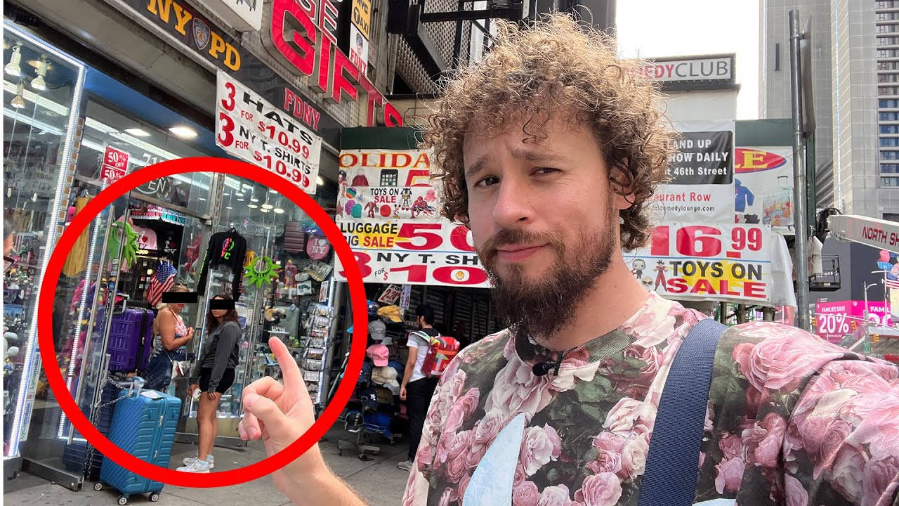 男人指著兩個在繁忙城市街道上購買紀念品的女士。