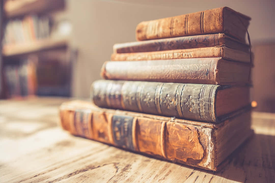 木桌上的舊書堆，柔和陽光。