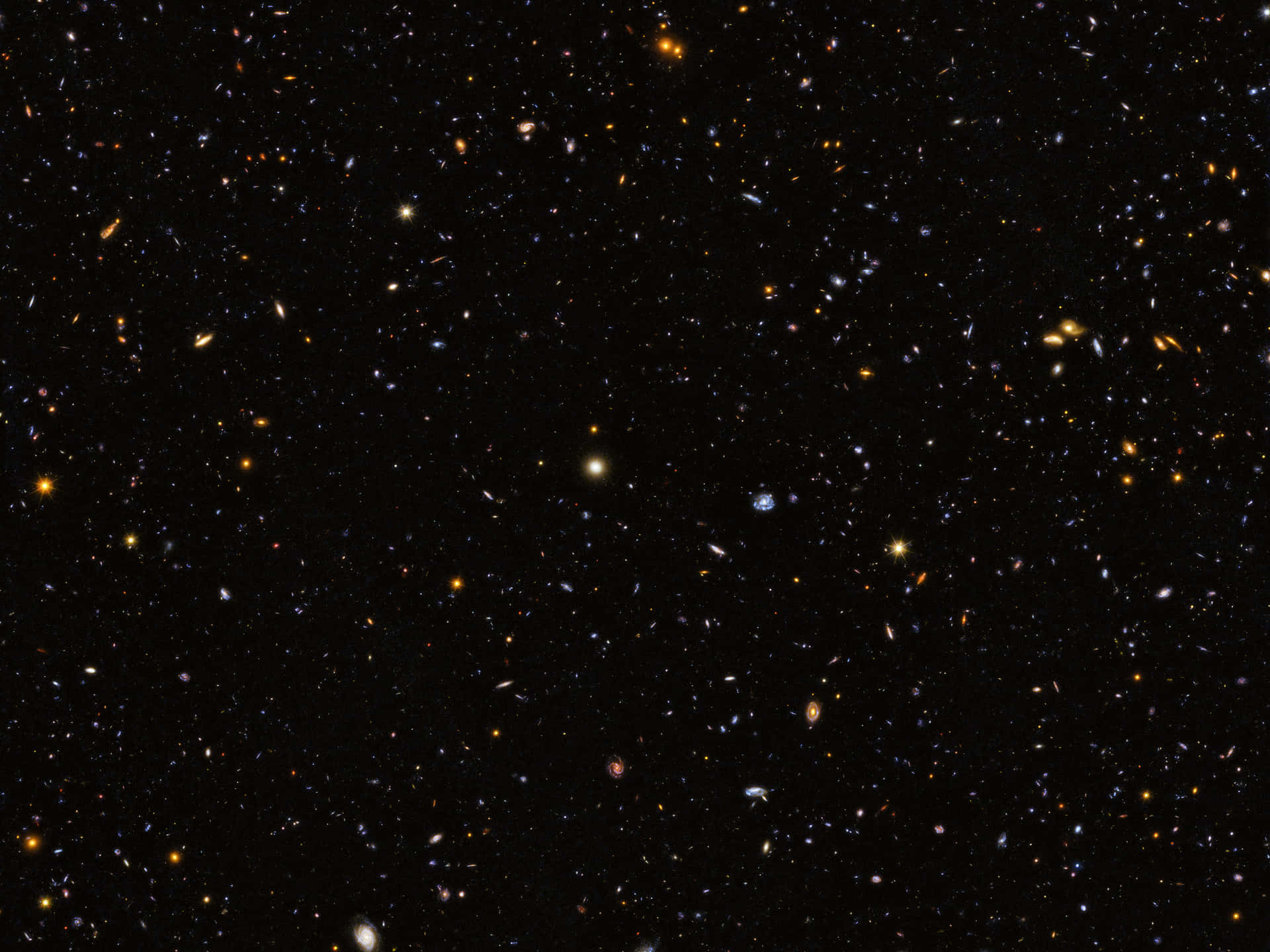 深空充滿遙遠星系，在黑色虛空中閃耀金色、藍色和白色光芒。