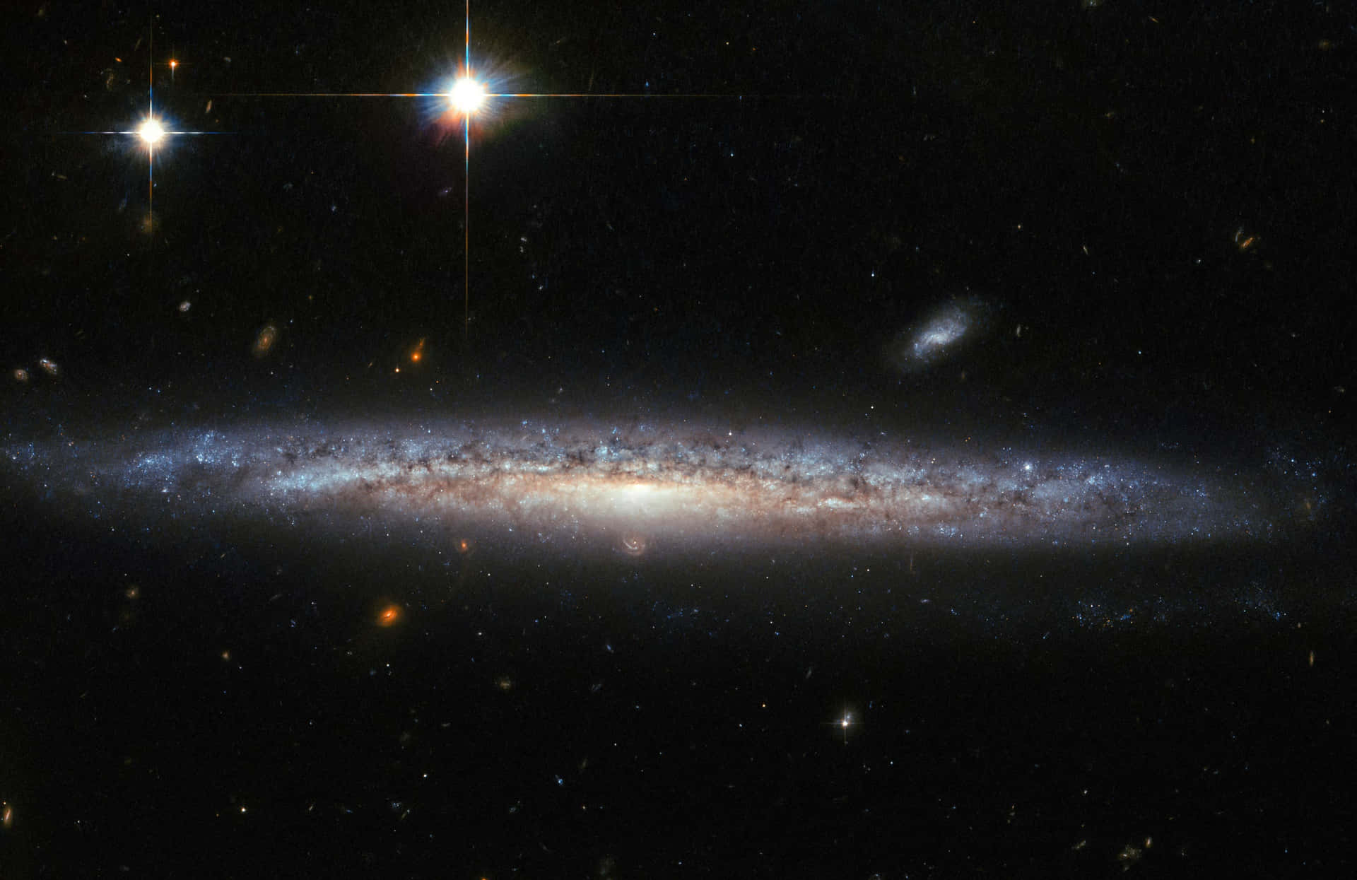 一個帶有藍色和橙色色調的螺旋星系，被深空中的星星包圍。