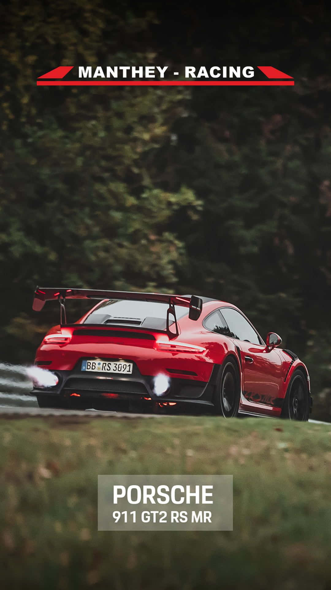 紅色保時捷911 GT2 RS MR在森林道路上奔馳，排氣管冒出煙霧。