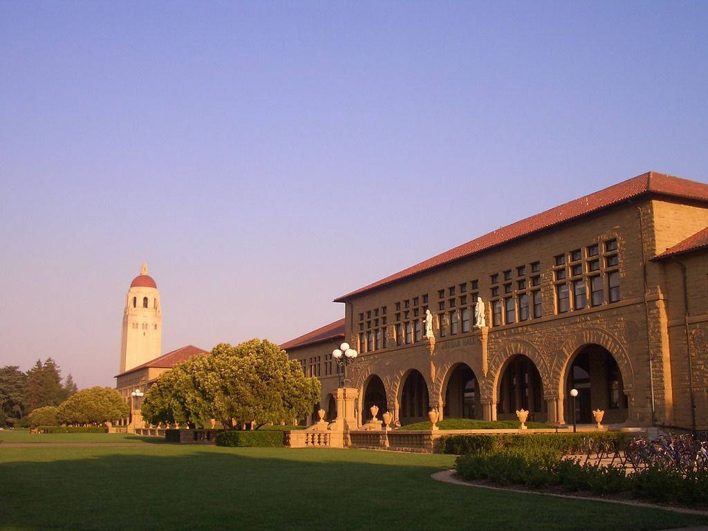 史丹福大學校園在夕陽下，歷史建築和綠色草坪。
