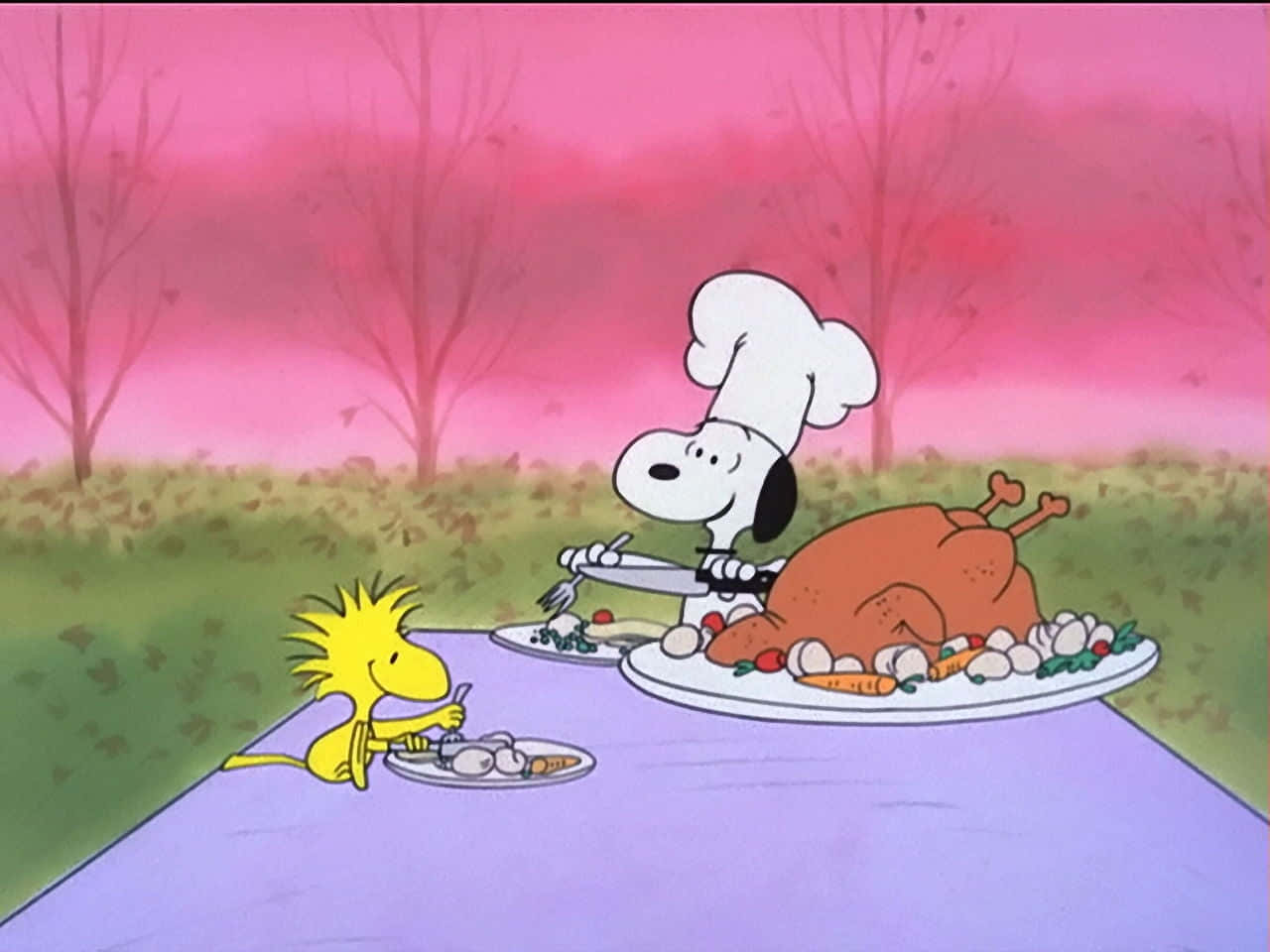Snoopy Fall 桌布 壁紙 — 史努比戴著廚師帽，在粉紅色天空下的戶外野餐桌旁為胡士托切火雞。
