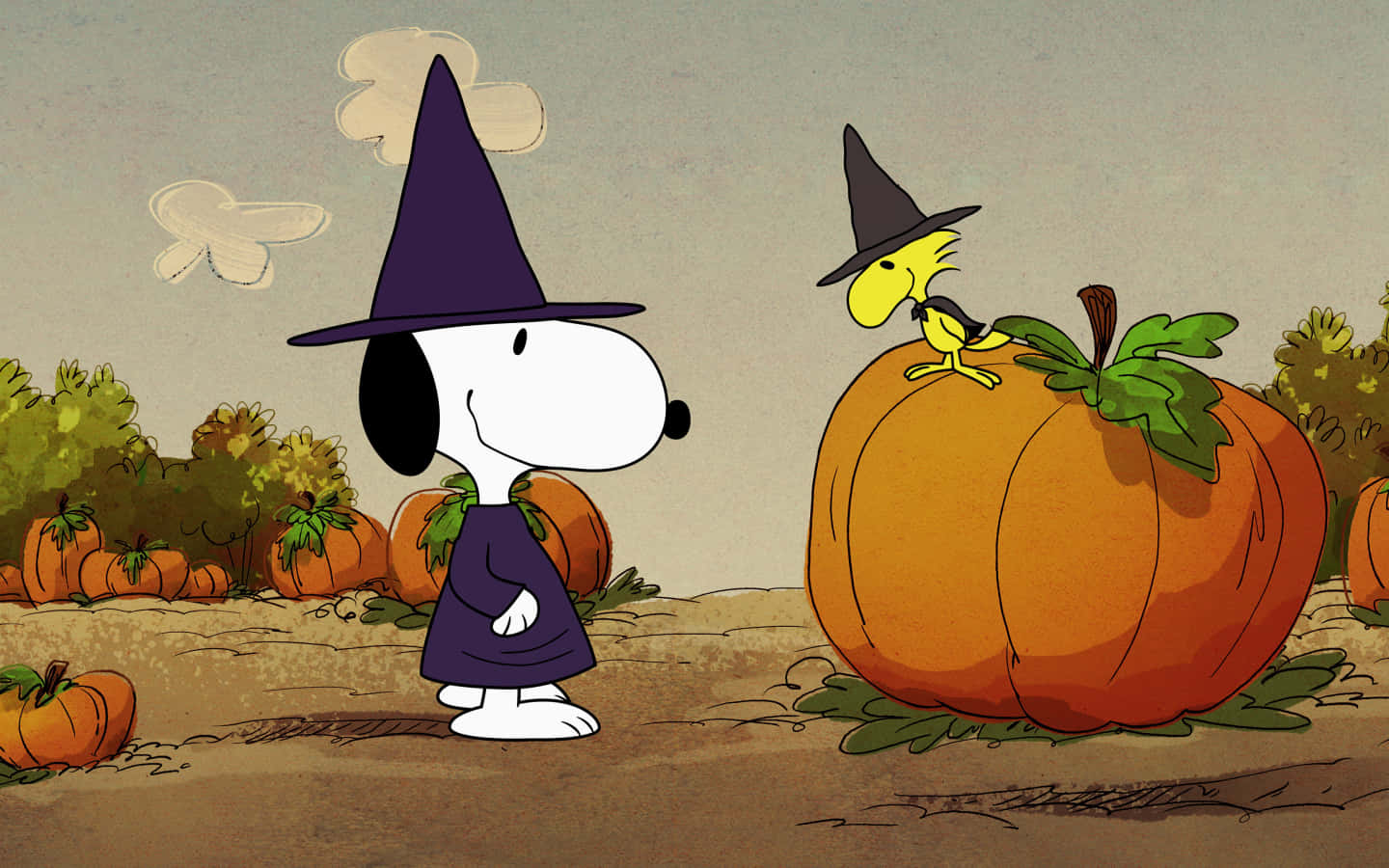 史努比 桌布 壁紙 — 史努比打扮成女巫，站在一個巨型南瓜旁邊，胡士托棲息在南瓜頂上，身處南瓜田。