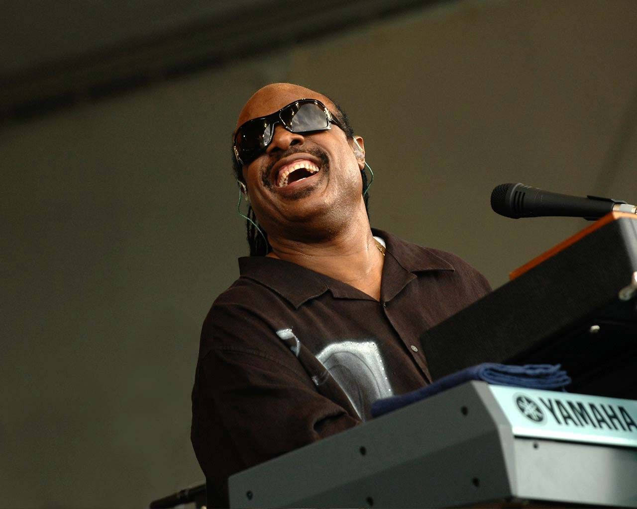 Snoop Dogg 在舞台上彈奏鍵盤時大笑。