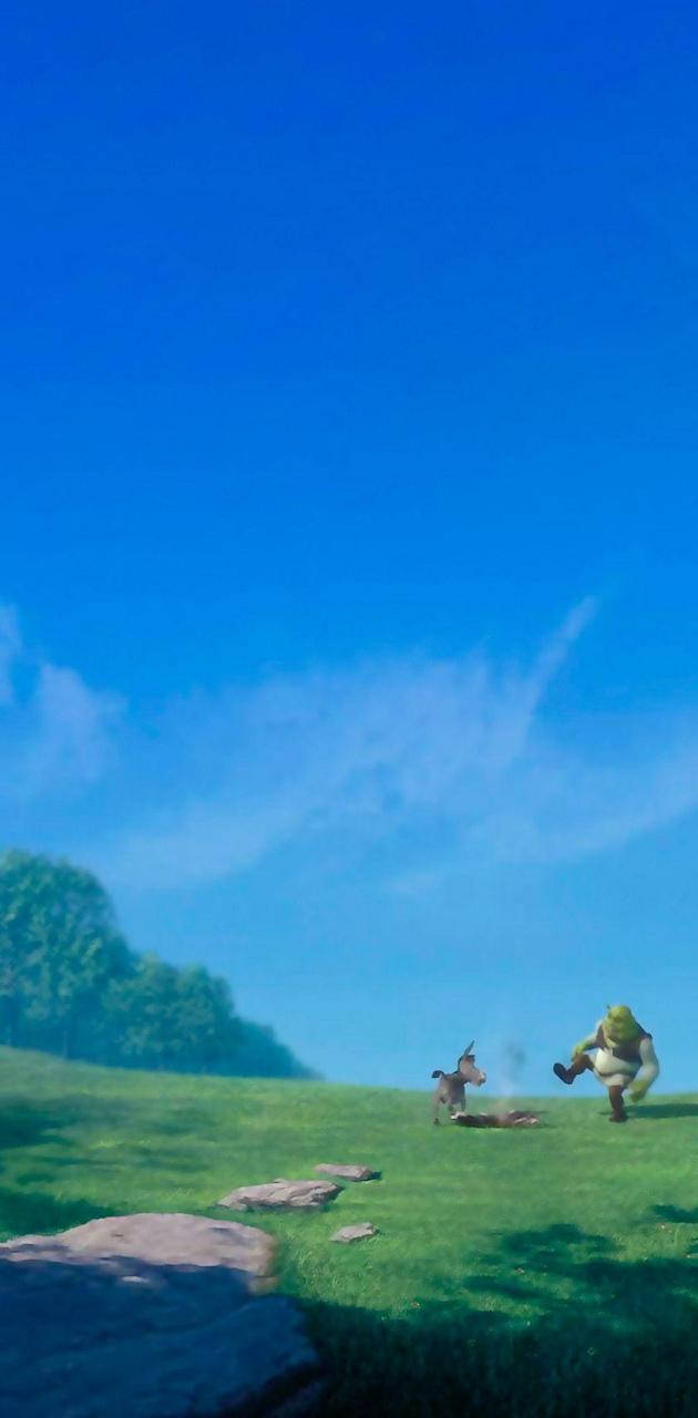 史瑞克與驢子滅火 壁紙 — 史力加和驢友在陽光普照的綠色山丘上快樂地奔跑，天空廣闊湛藍，有縷縷薄雲。