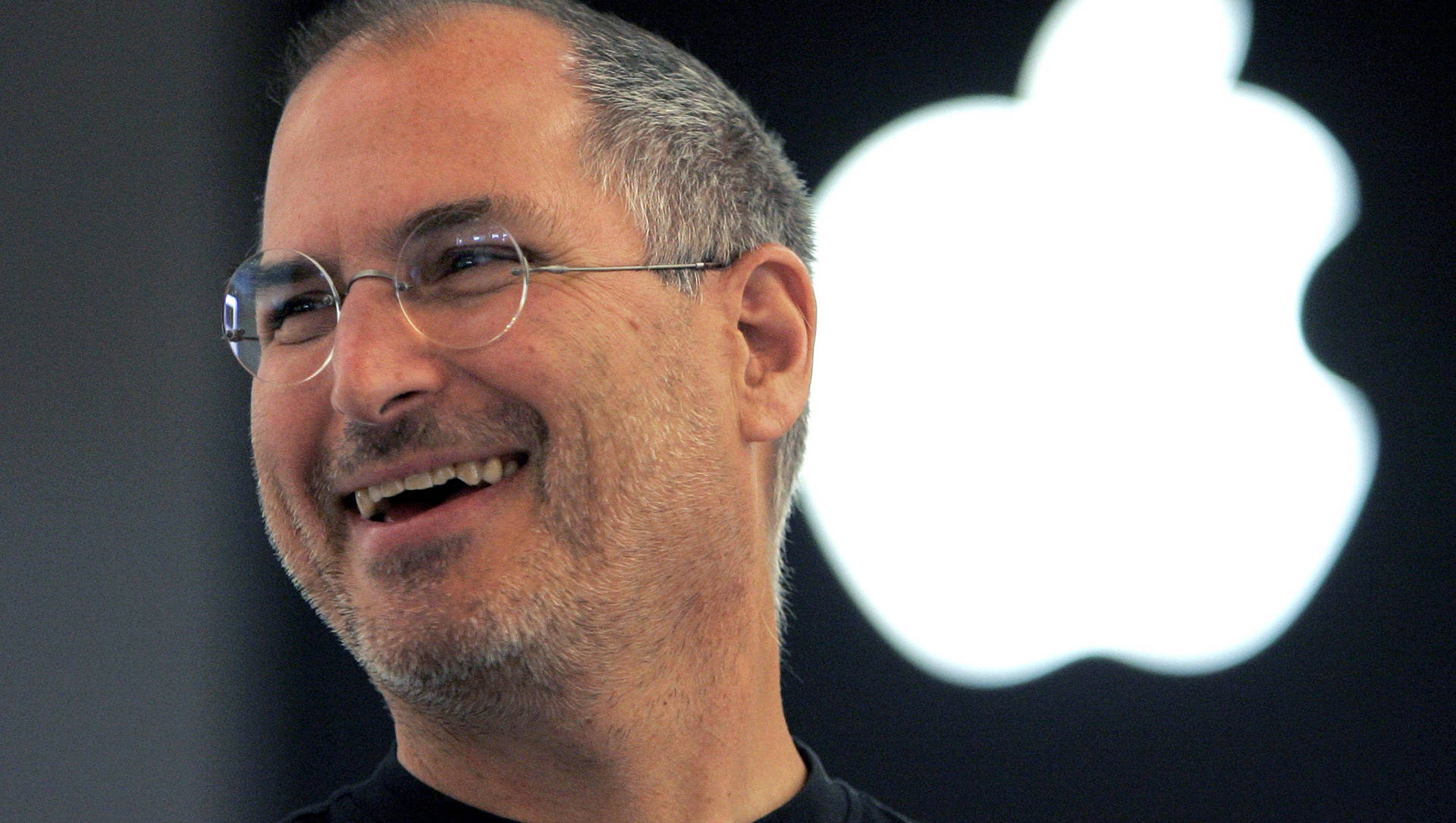 Steve Jobs 微笑，背後有 Apple 標誌