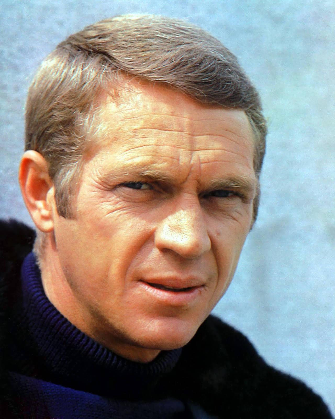 史蒂夫·麥克queen 飾演Bullitt 1968年肖像 壁紙 — 一名短棕髮男子身穿深色高領毛衣，以紋理藍色背景為襯的 close-up 肖像。