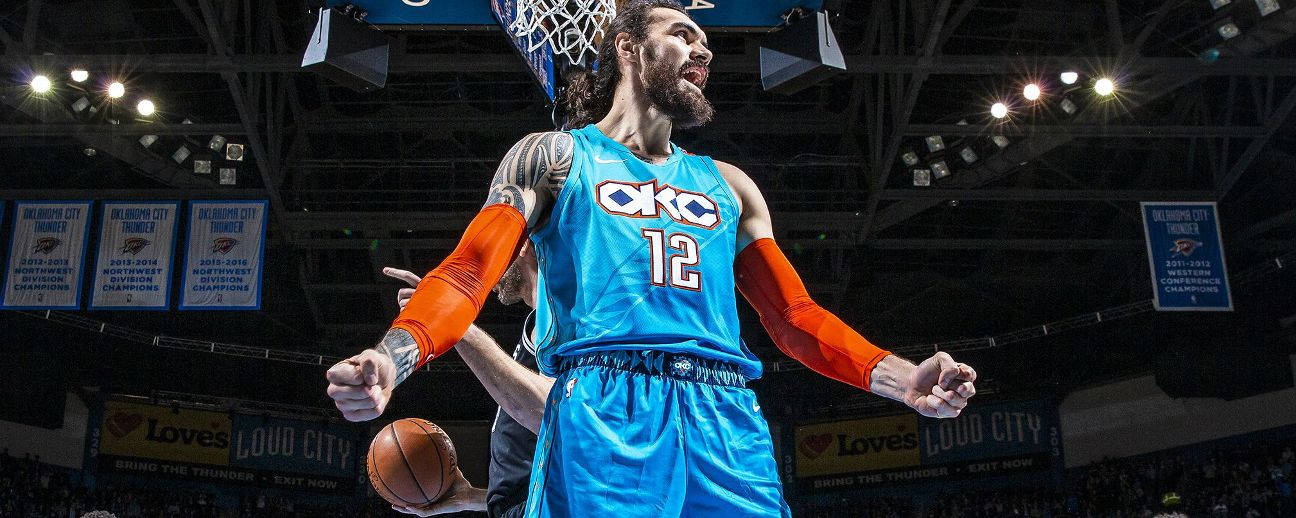 史蒂文·亞當斯 OKC 球隊球員 壁紙 — 一名身穿藍色OKC球衣的籃球運動員在場館燈光下慶祝入樽，背景有冠軍旗幟。