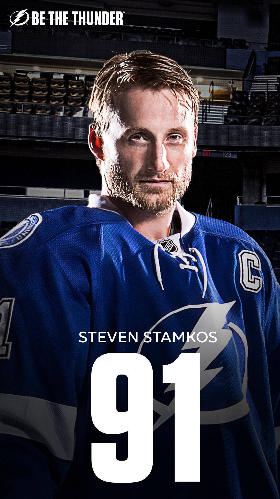 史蒂文·史塔科斯冰球運動員91號雷霆隊 壁紙 — 冰球運動員 Steven Stamkos 身穿藍色坦帕灣閃電隊 91 號球衣及隊長 'C' 標誌，在黑暗的競技場背景下的特寫肖像。