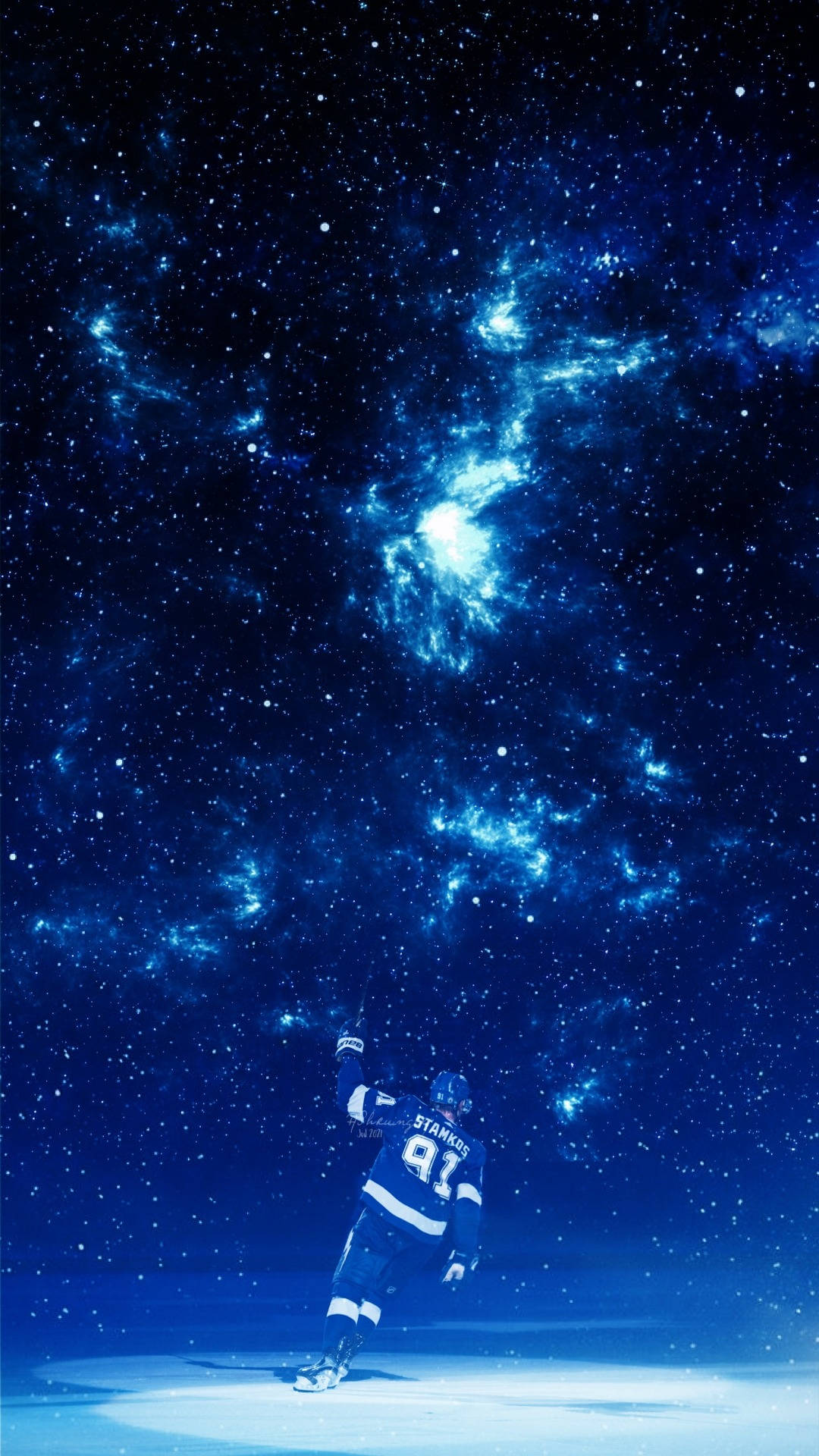 史蒂文·斯塔姆科斯 魔幻冰球 坦帕灣光芒隊 壁紙 — 一名穿著藍色裝備的曲棍球運動員站在冰上，頭頂是廣闊的星雲，散發著電光藍色的宇宙光芒。