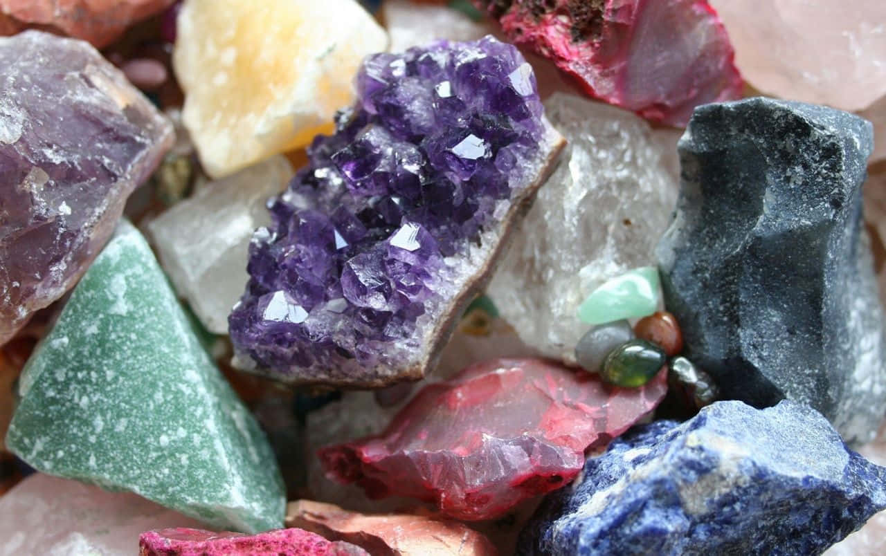 Amethyst 桌布 壁紙 — 各種未經打磨的晶體，包括紫色紫水晶和綠色東陵玉，緊密相依的鮮明特寫。