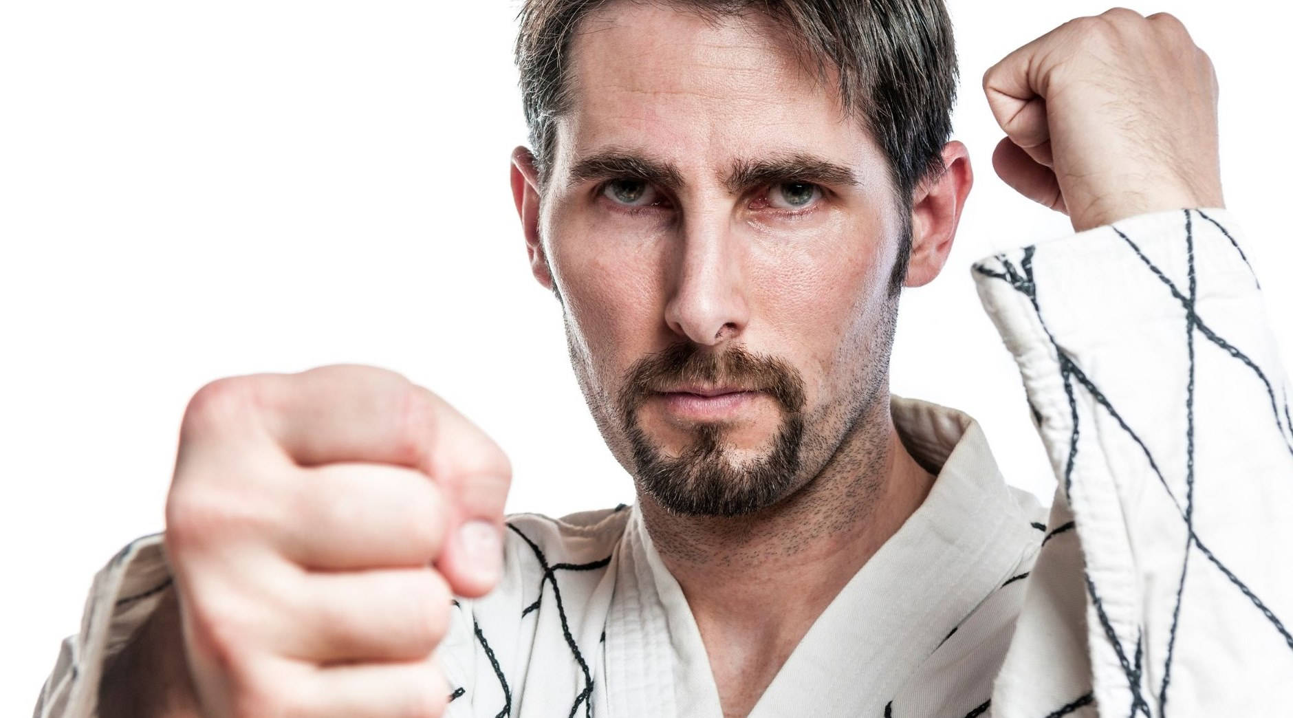 一名穿著武術制服的男人帶著堅定的表情向前出拳。