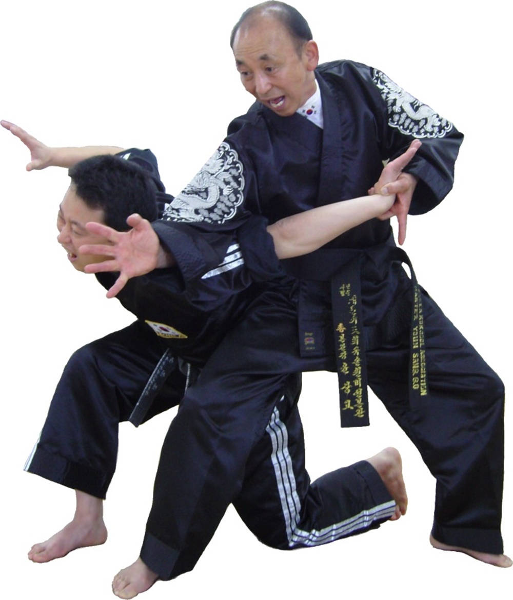 兩名身穿武術制服嘅男子練習摔跤動作。