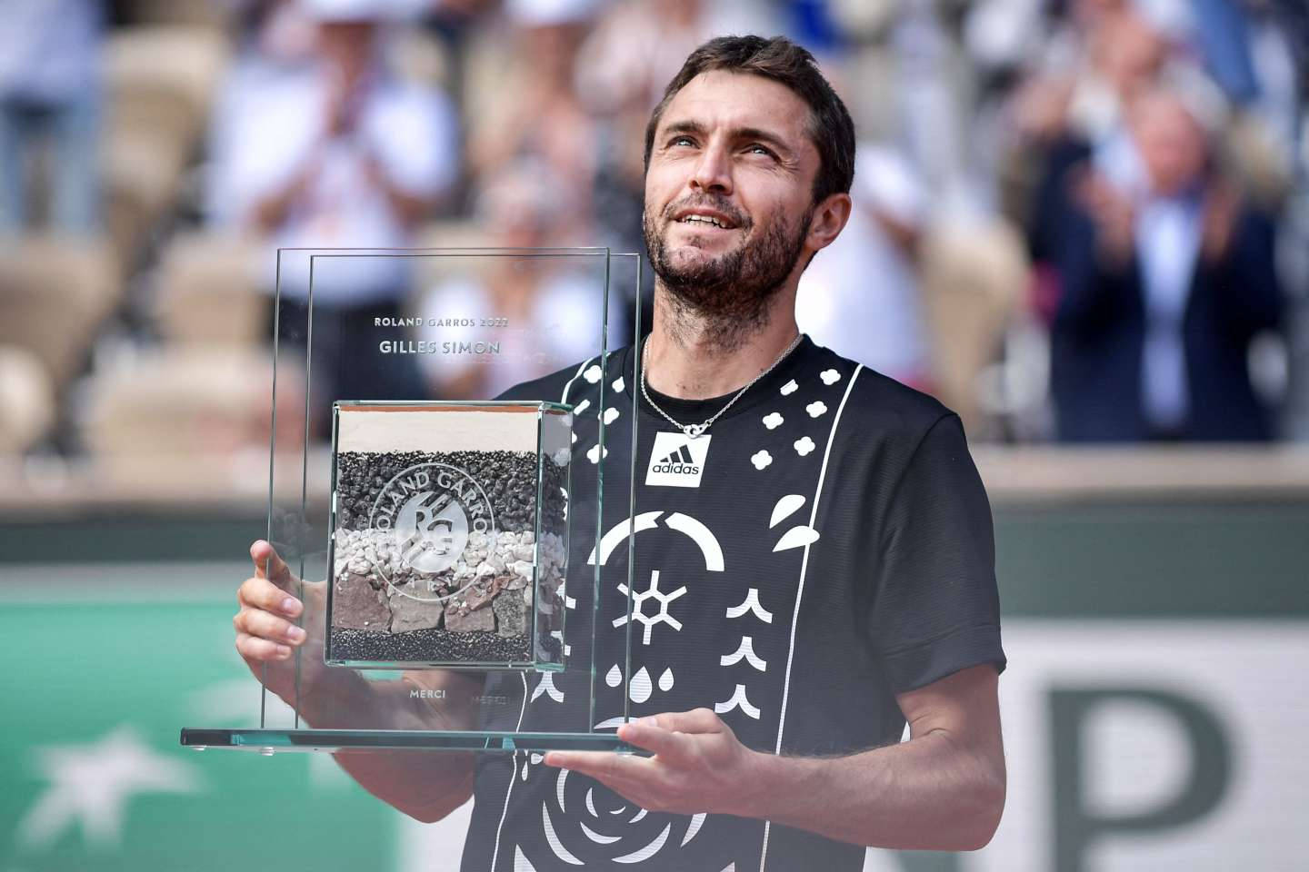 網球冠軍 Gilles Simon 帶著喜悅的表情捧著他的 Roland Garros 獎盃。