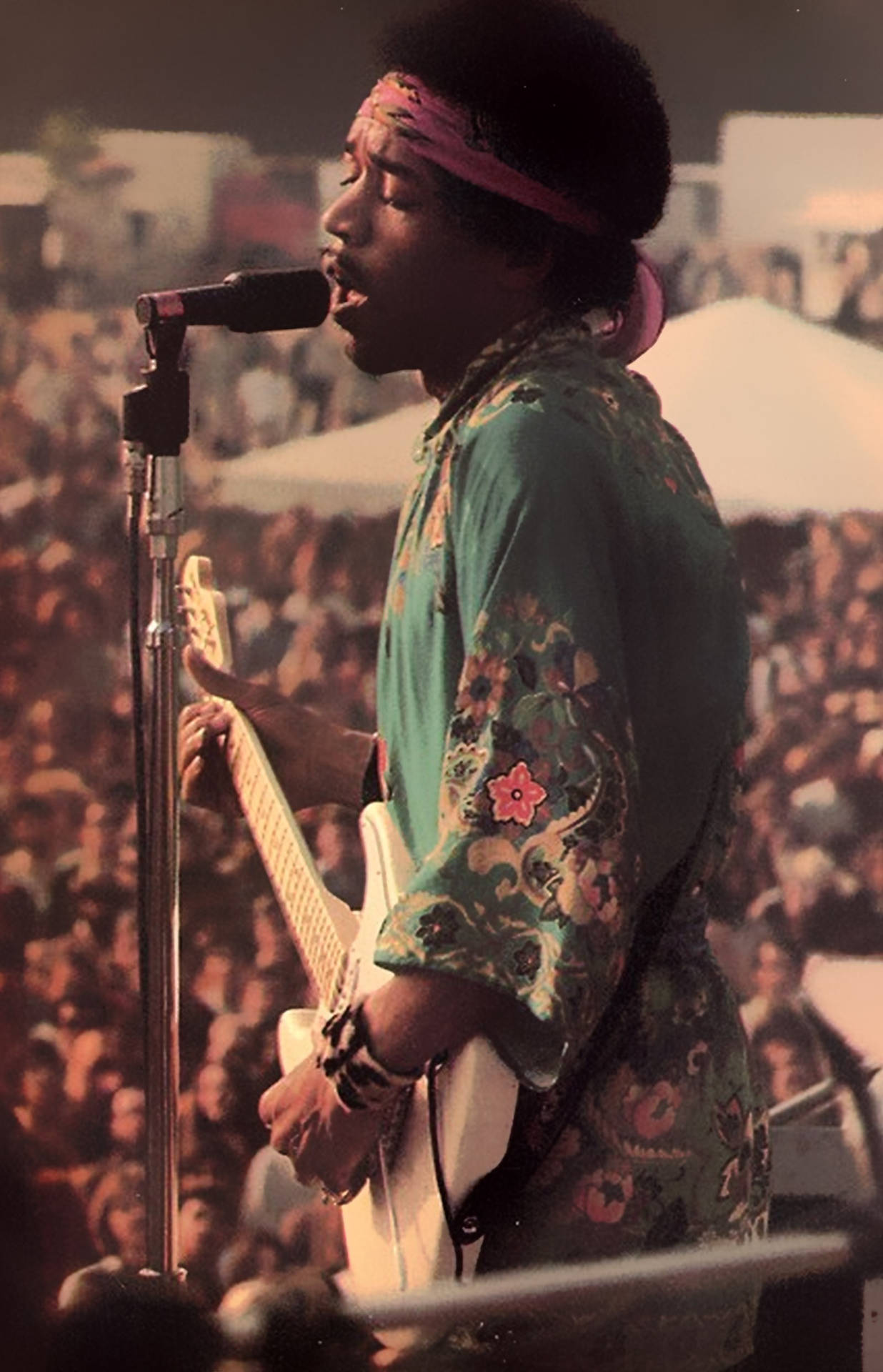 Jimi Hendrix 在音樂會上以結他和咪高峰現場表演。