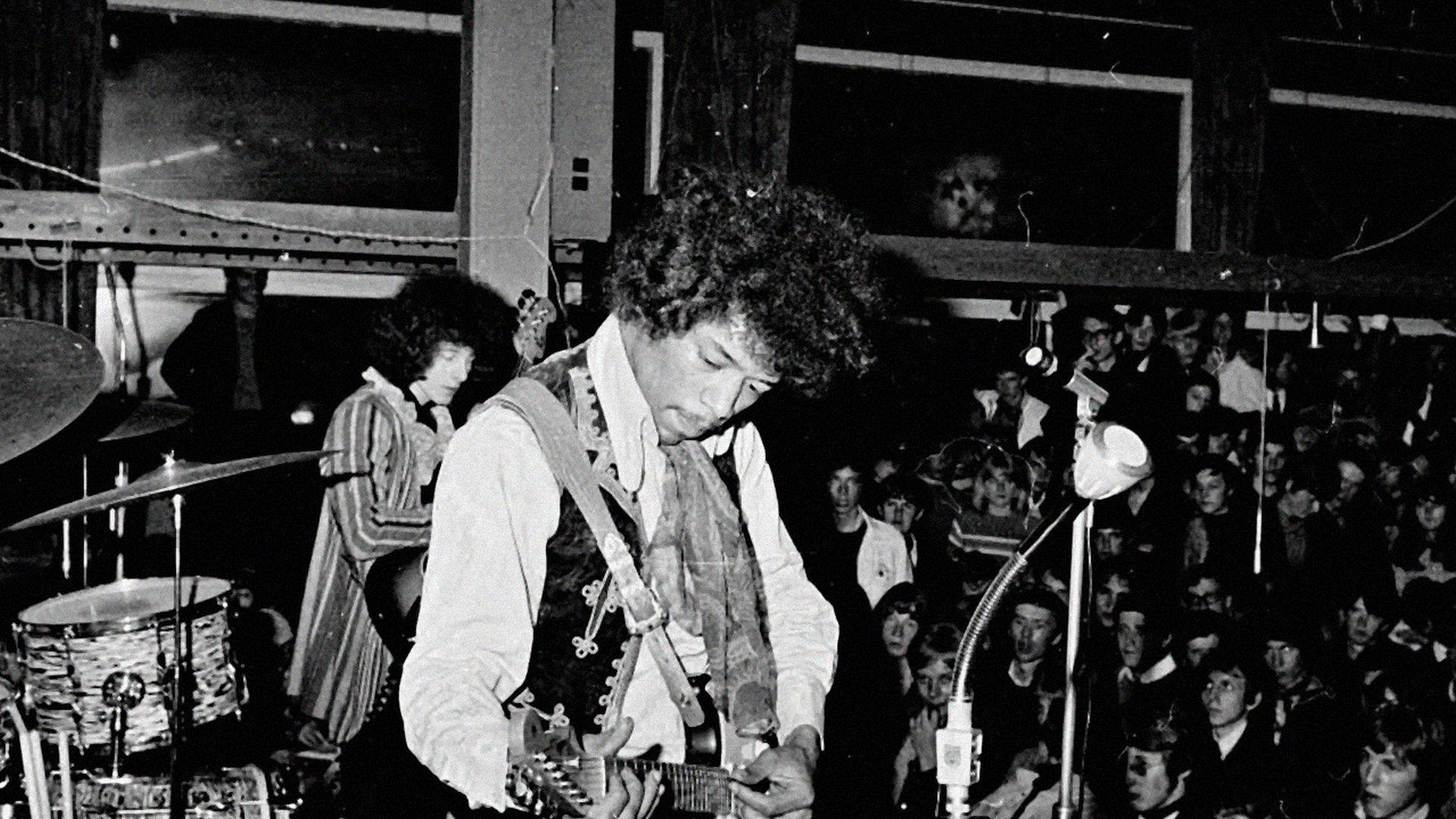 Bob Dylan 在1960年代的音樂會上，拿著結他在觀眾面前現場表演。