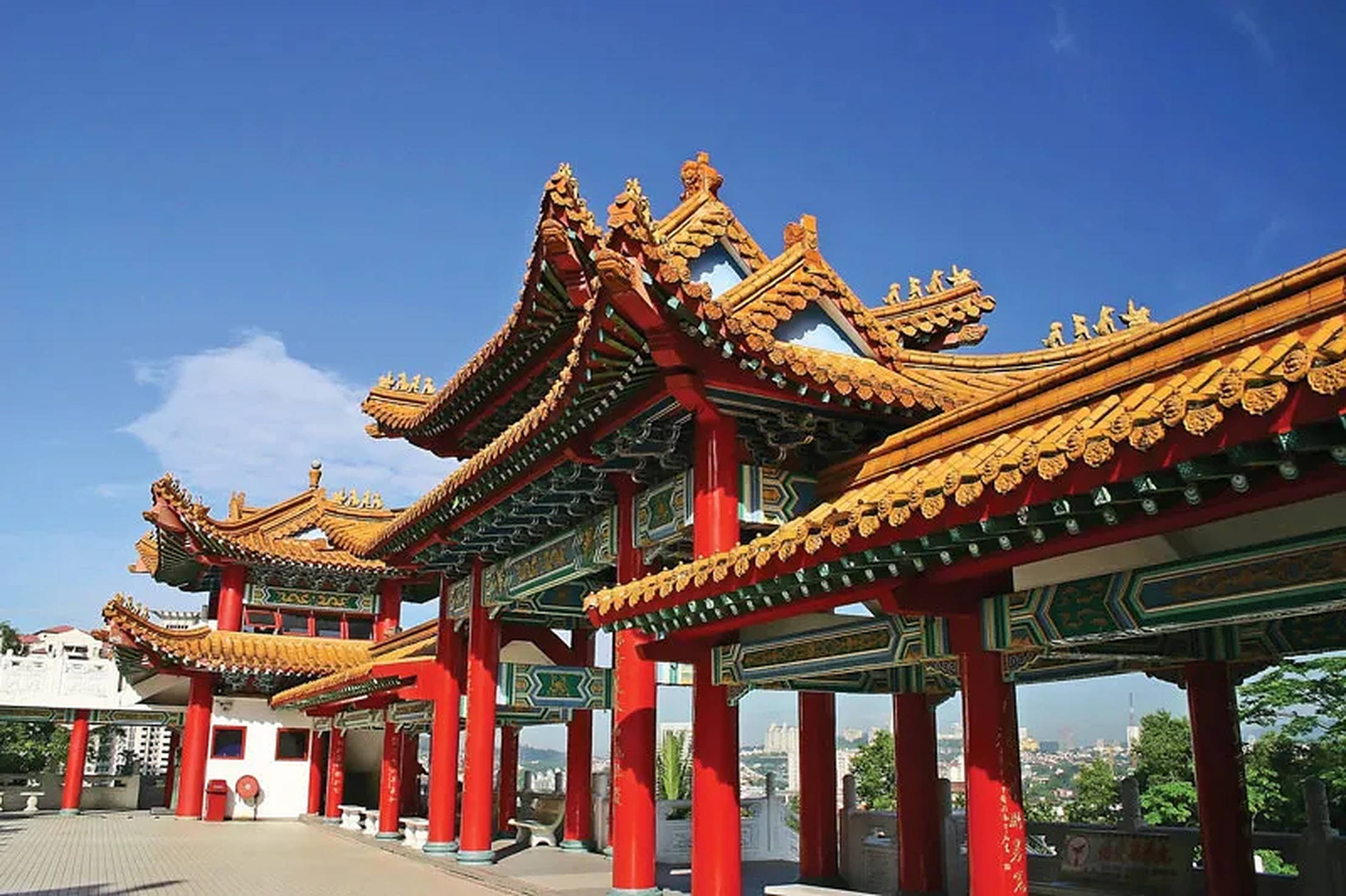 吉隆坡天后宮 壁紙 — 色彩鮮豔的傳統中式亭閣，飾有華麗的金色屋頂和紅色柱子，在清澈的藍天下。