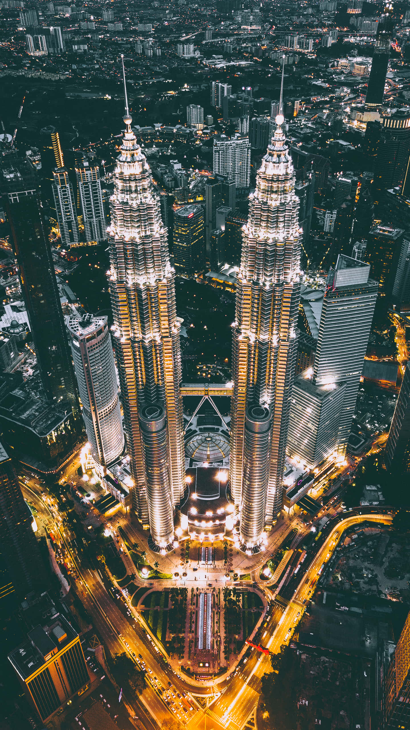 Malaysia 桌布 壁紙 — 吉隆坡雙峰塔在夜晚發光的鳥瞰圖，下方有城市燈光和交通。