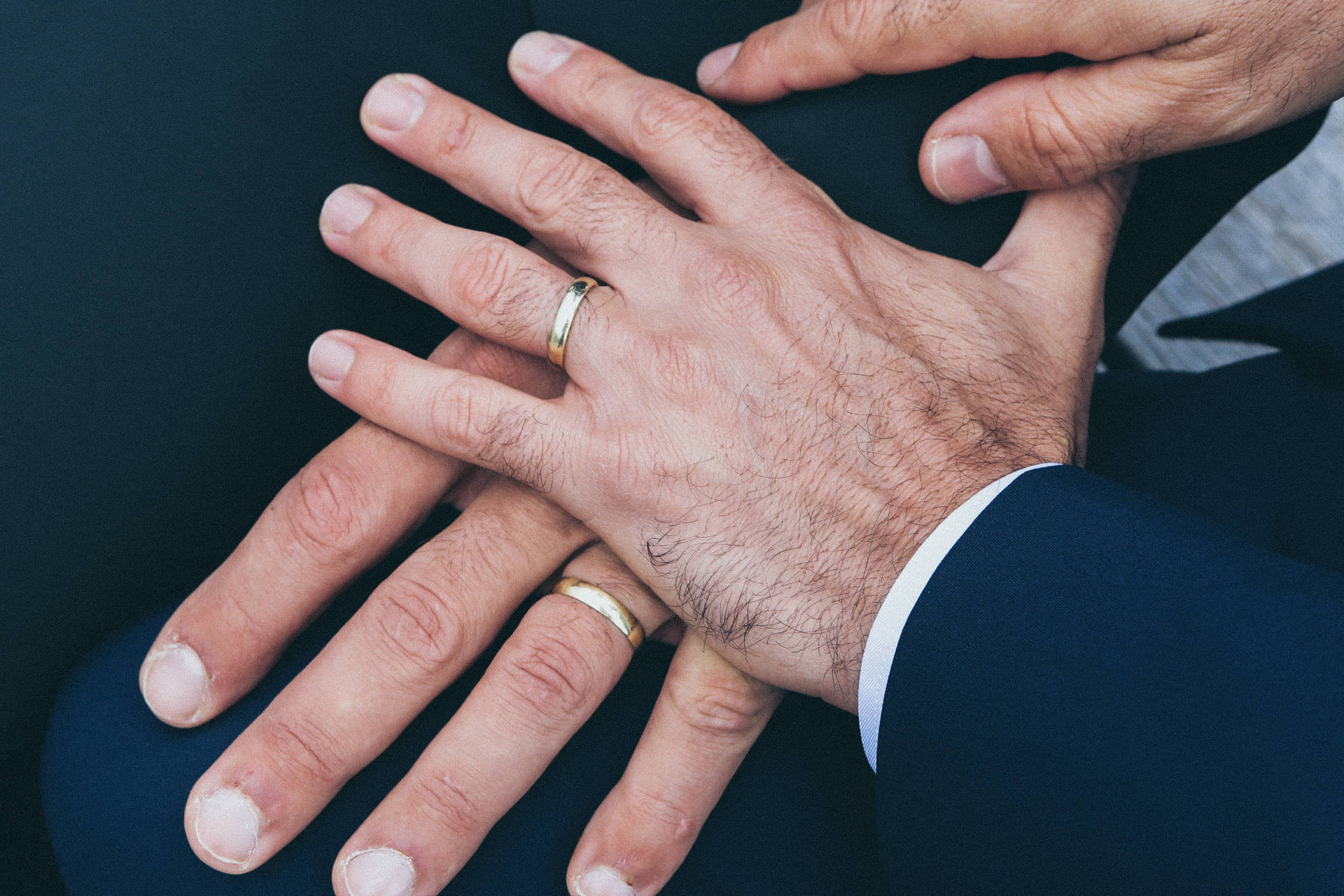 兩隻手緊握在一起，手指上戴著結婚戒指。