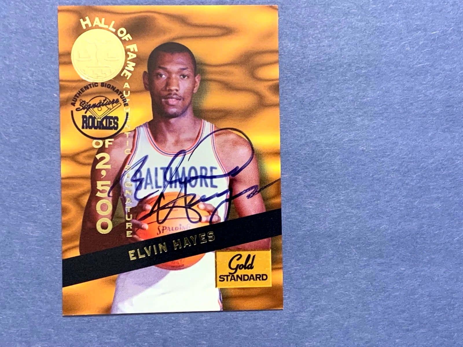 簽名嘅 Elvin Hayes 名人堂新秀籃球卡，藍色背景。