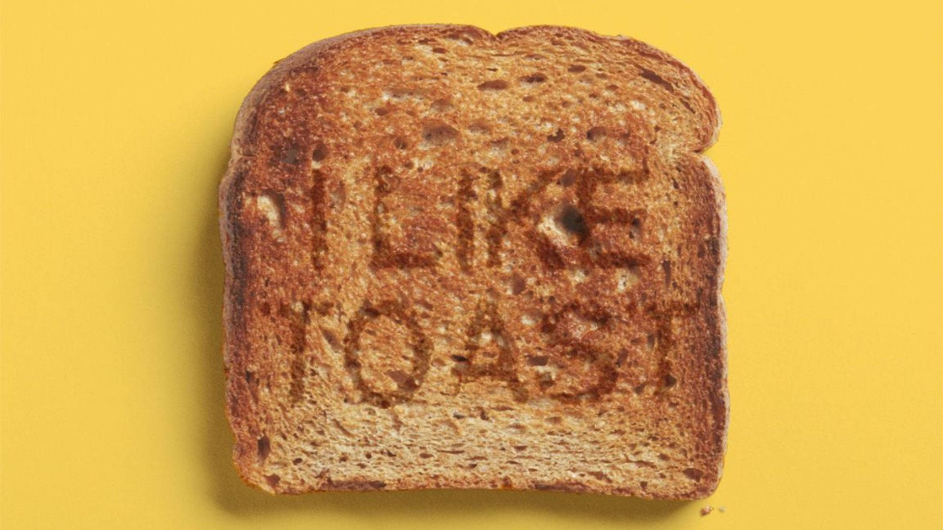 一片多士，上面烤有「I LIKE TOAST」字樣，背景為黃色。