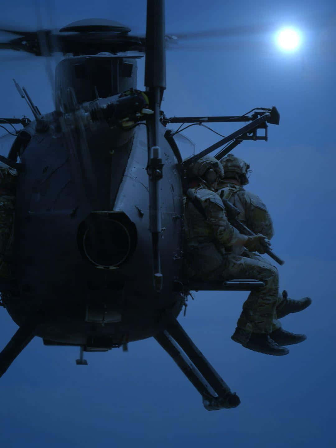 向印度軍隊的英雄致敬 壁紙 — 兩名身穿迷彩裝備的士兵坐在軍用直升機側面，背景是明亮的月光天空。