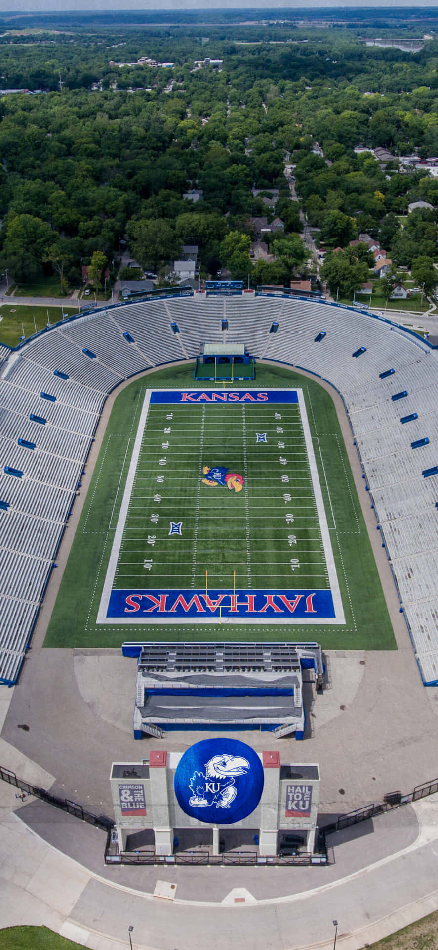 一個空蕩蕩的堪薩斯捷鷹隊足球場的鳥瞰圖，周圍環繞著樹木。
