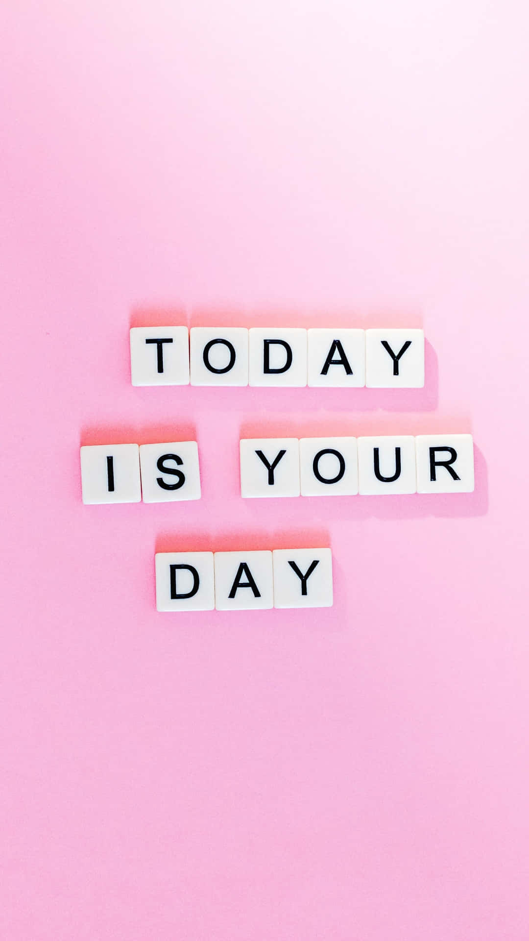 白色字母瓷磚在粉紅色背景上拼出「Today Is Your Day」。