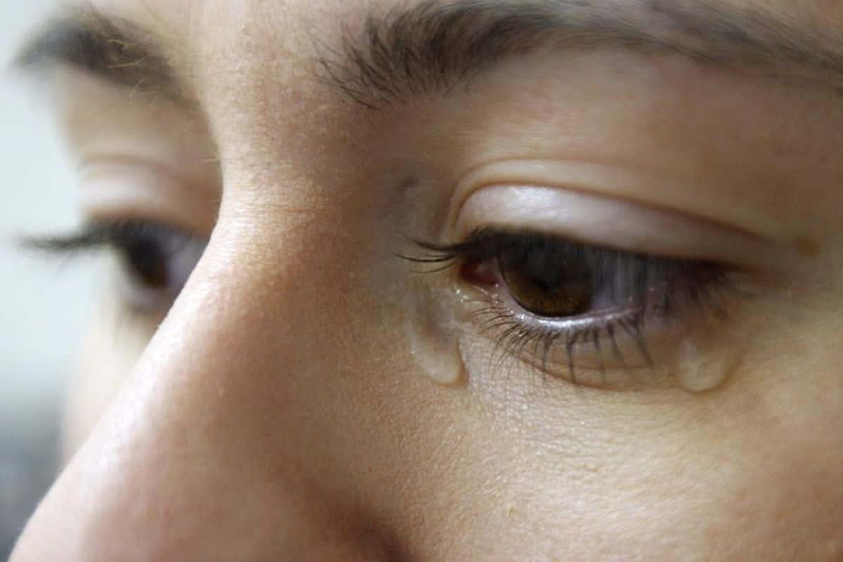女性眼睛特寫，一滴淚水順著臉頰滑落。