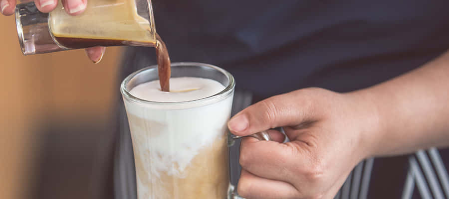 Milk And Coffee 桌布 壁紙 — 咖啡師將濃郁的濃縮咖啡倒入裝滿奶油牛奶的玻璃杯中，創造出分層咖啡飲品。