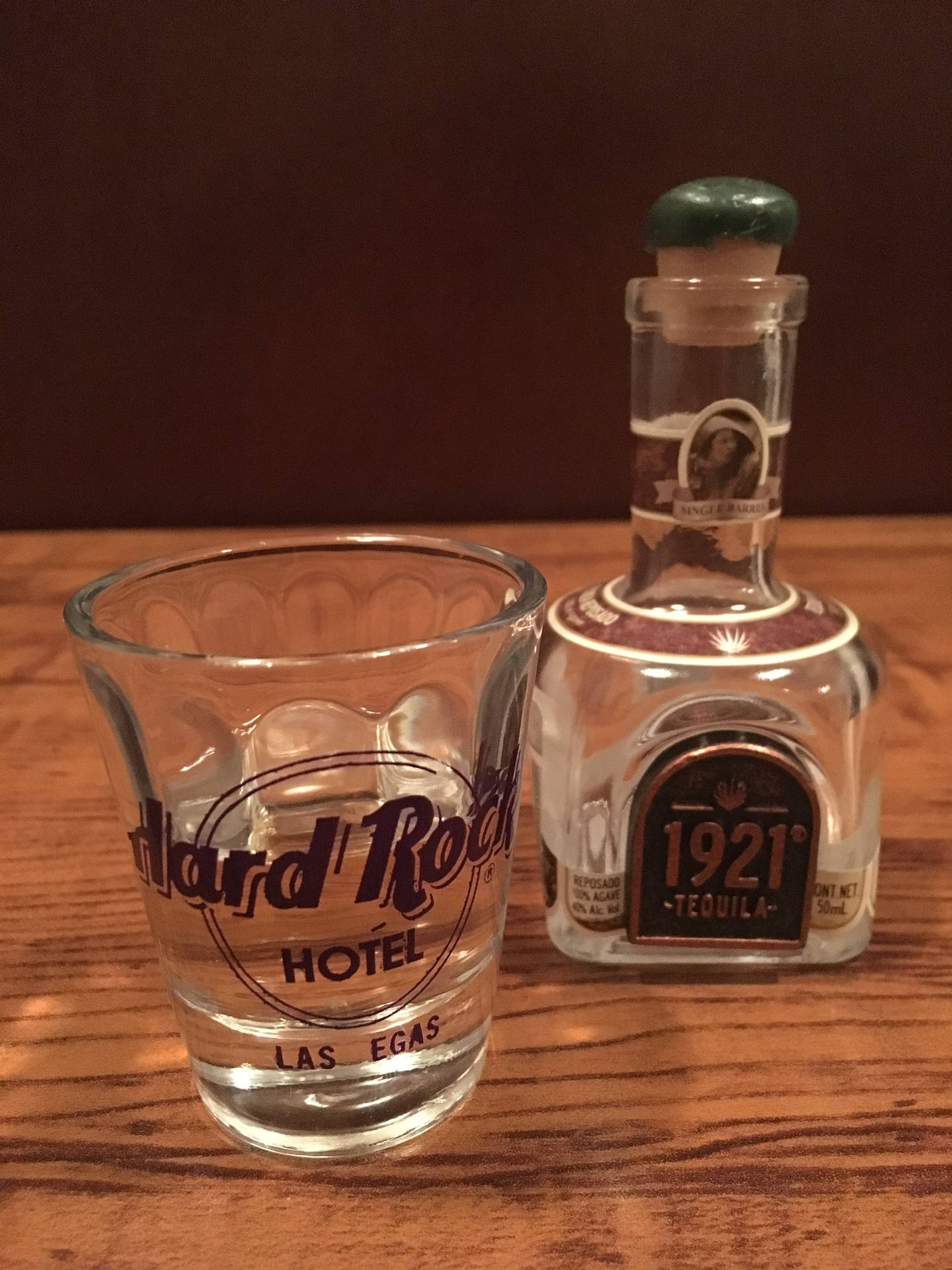 Hard Rock Hotel Las Vegas烈酒杯旁邊有一瓶1921龍舌蘭酒在木頭上。