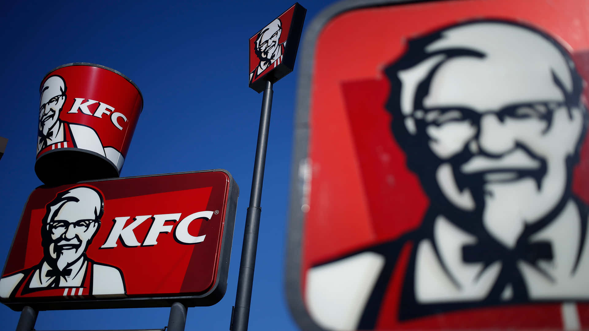 KFC餐廳招牌，帶有山德士上校標誌，背景為藍天