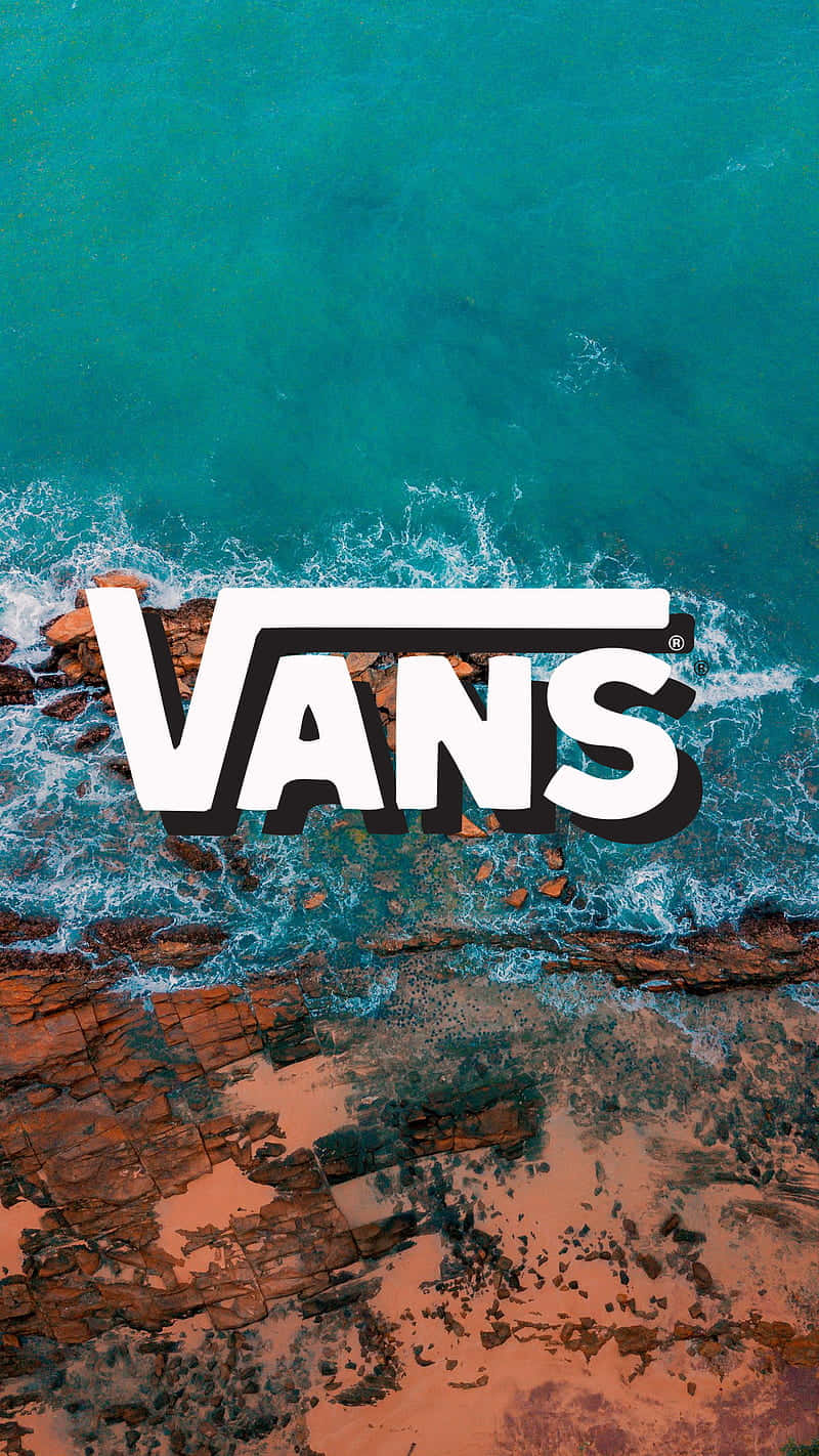 從上方俯瞰，Vans標誌疊加在拍打紅色岩石的海浪上。