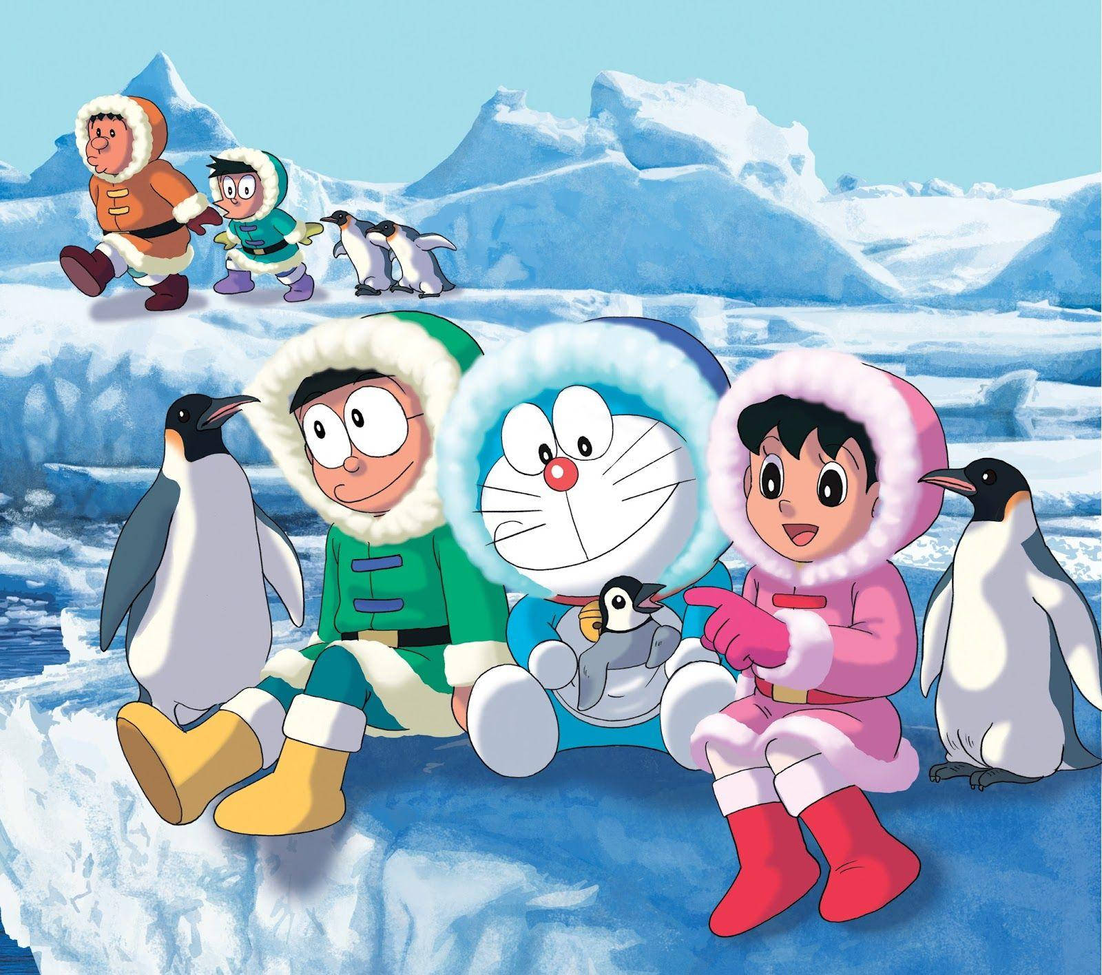 哆啦A夢在雪地 壁紙 — 多啦A夢和朋友們穿著冬季裝備，坐在冰天雪地上，背景是白雪覆蓋的山脈，與企鵝一起。