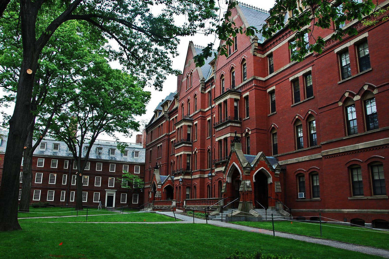 紅磚大學建築，哥德式建築風格，周圍環繞著綠樹和草坪。