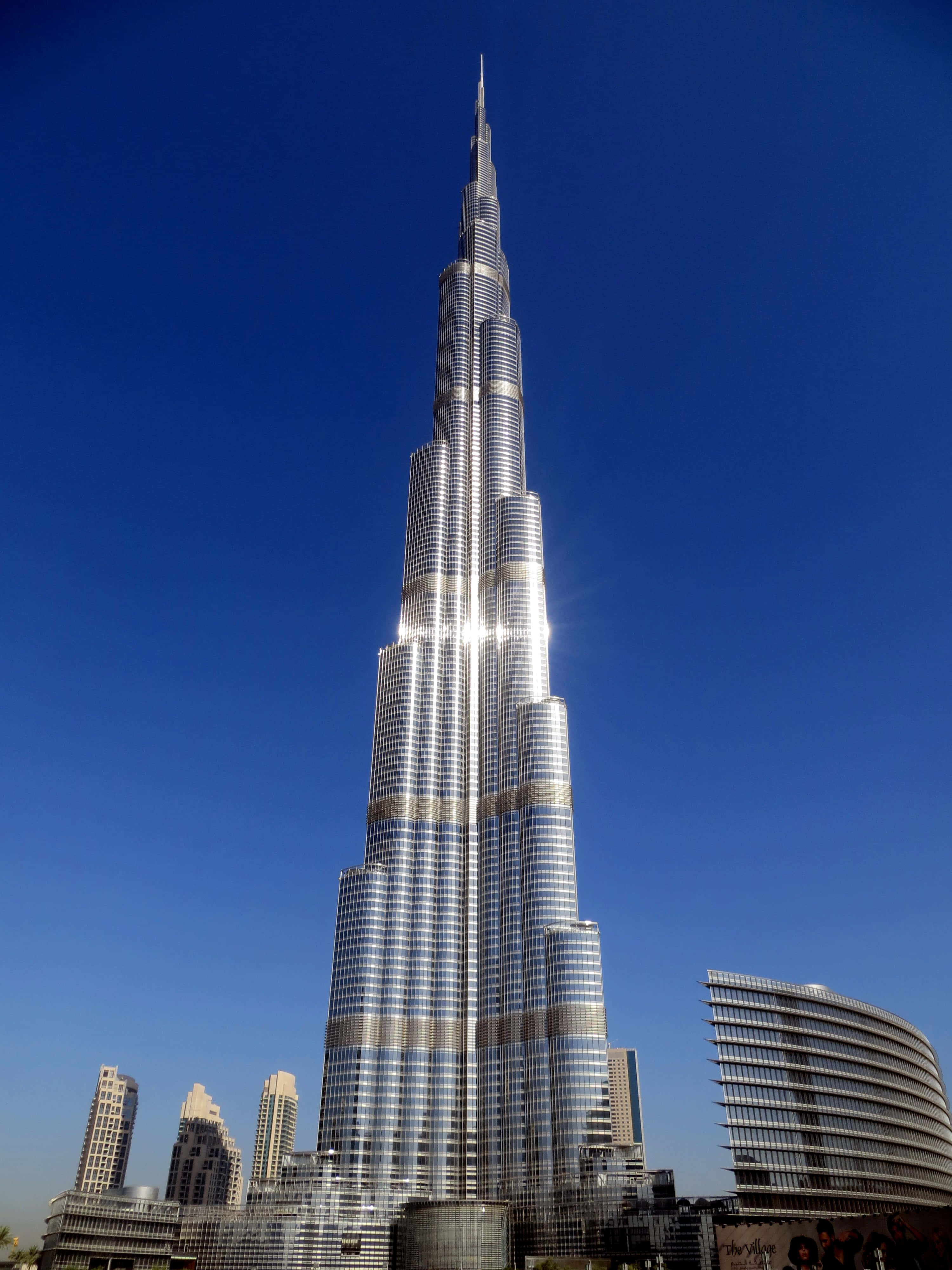 Burj Khalifa 桌布 壁紙 — 哈利法塔在晴朗的藍天下雄偉地聳立，陽光在其玻璃外牆上閃爍。