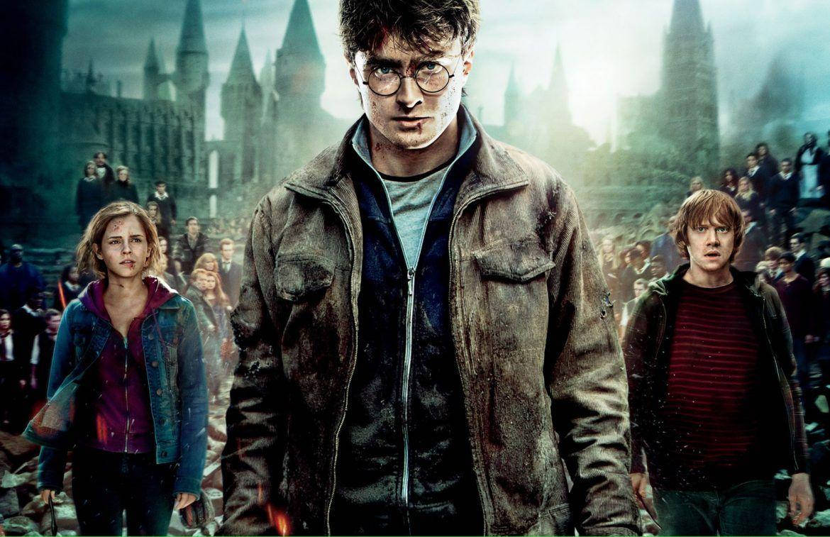 Hermione Granger 桌布 壁紙 — 哈利波特與妙麗和榮恩一起站在一個滿是戰鬥痕跡的庭院中，充滿挑釁，而霍格華茲在迷霧暮色中聳立在他們身後。