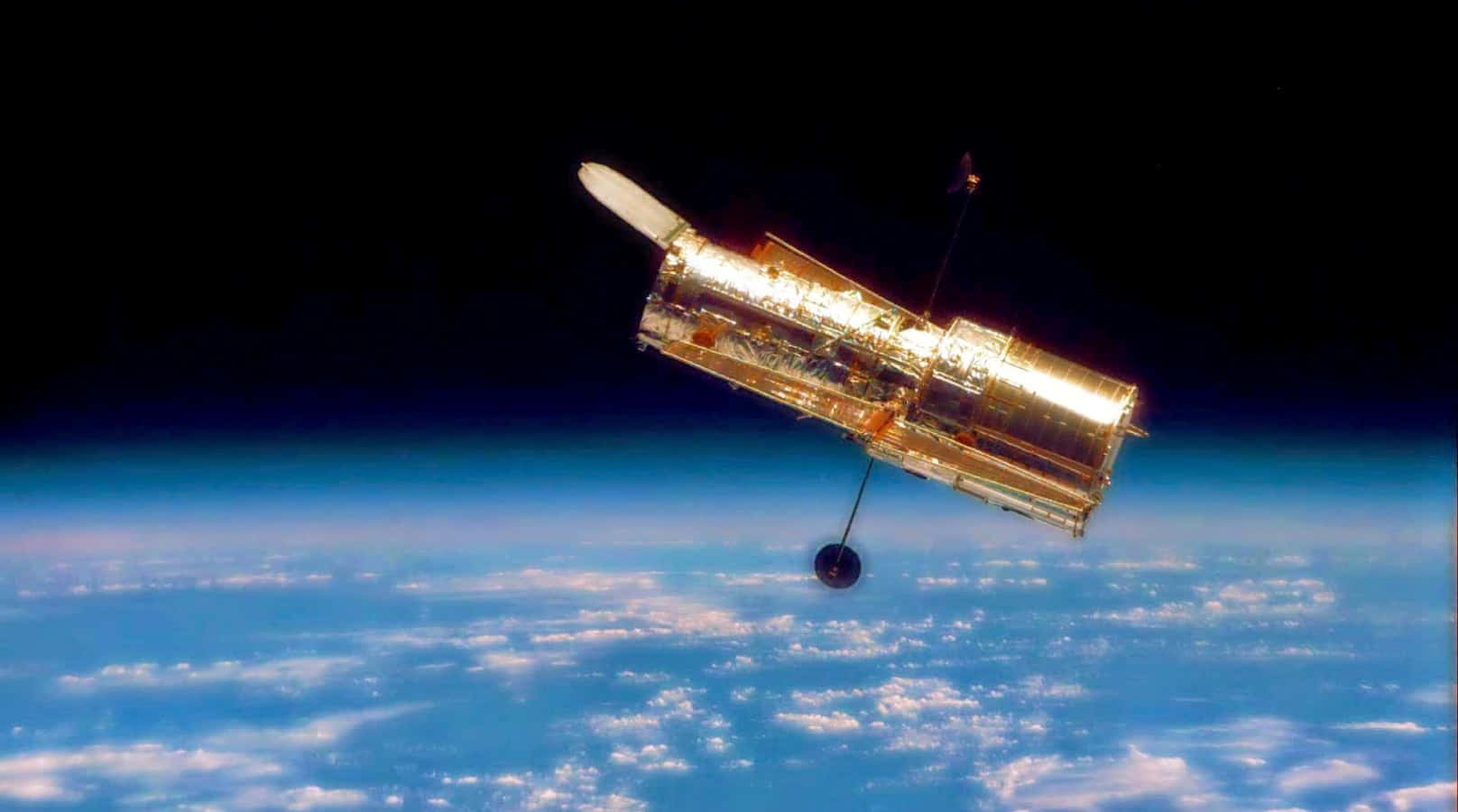 Hubble Space Telescope 桌布 壁紙 — 哈勃太空望远镜在太空的黑暗中，以金色光芒映衬着地球蓝白相间的云层曲线。